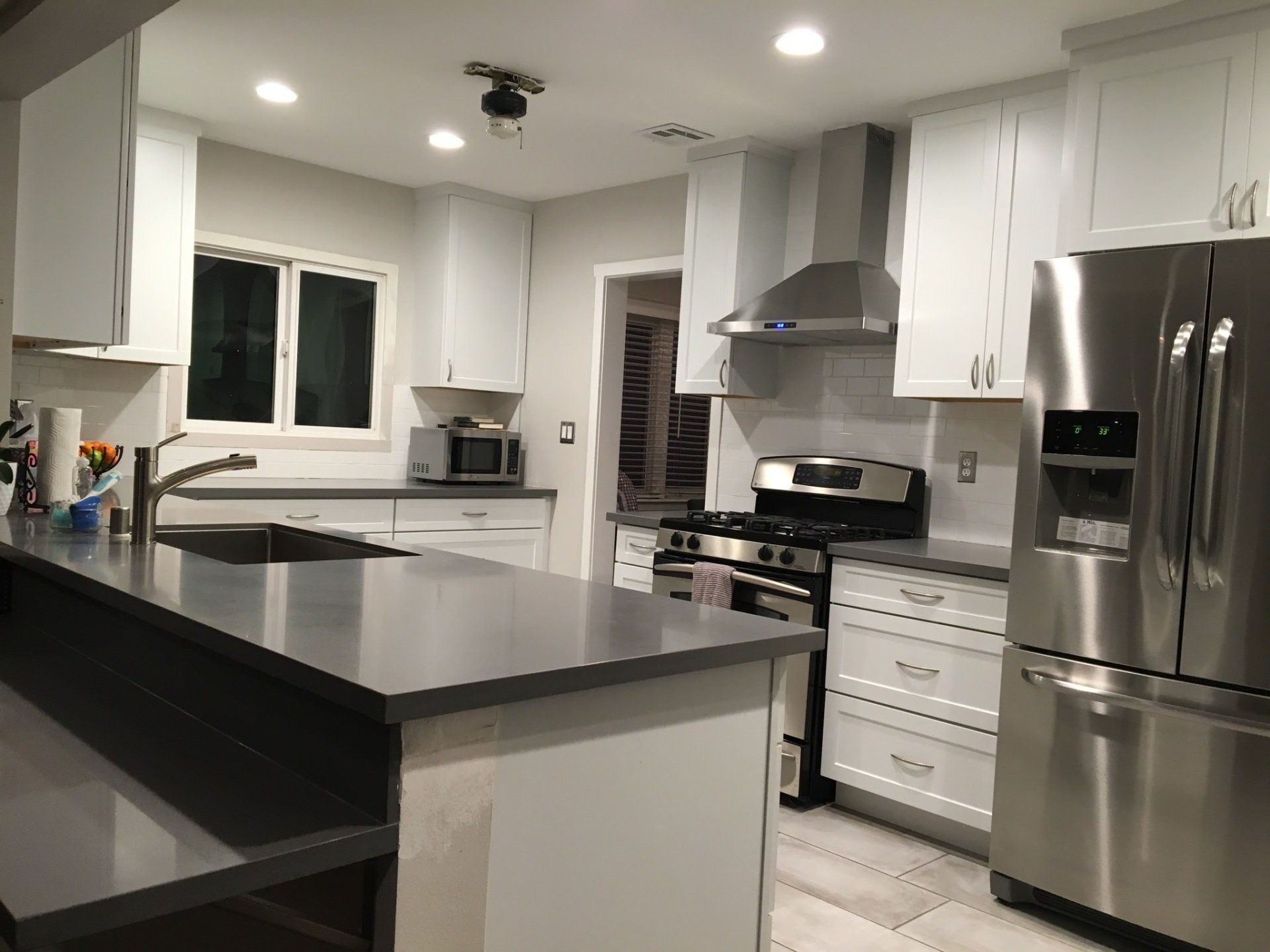 A kitchen with stainless steel appliances and white cabinets
