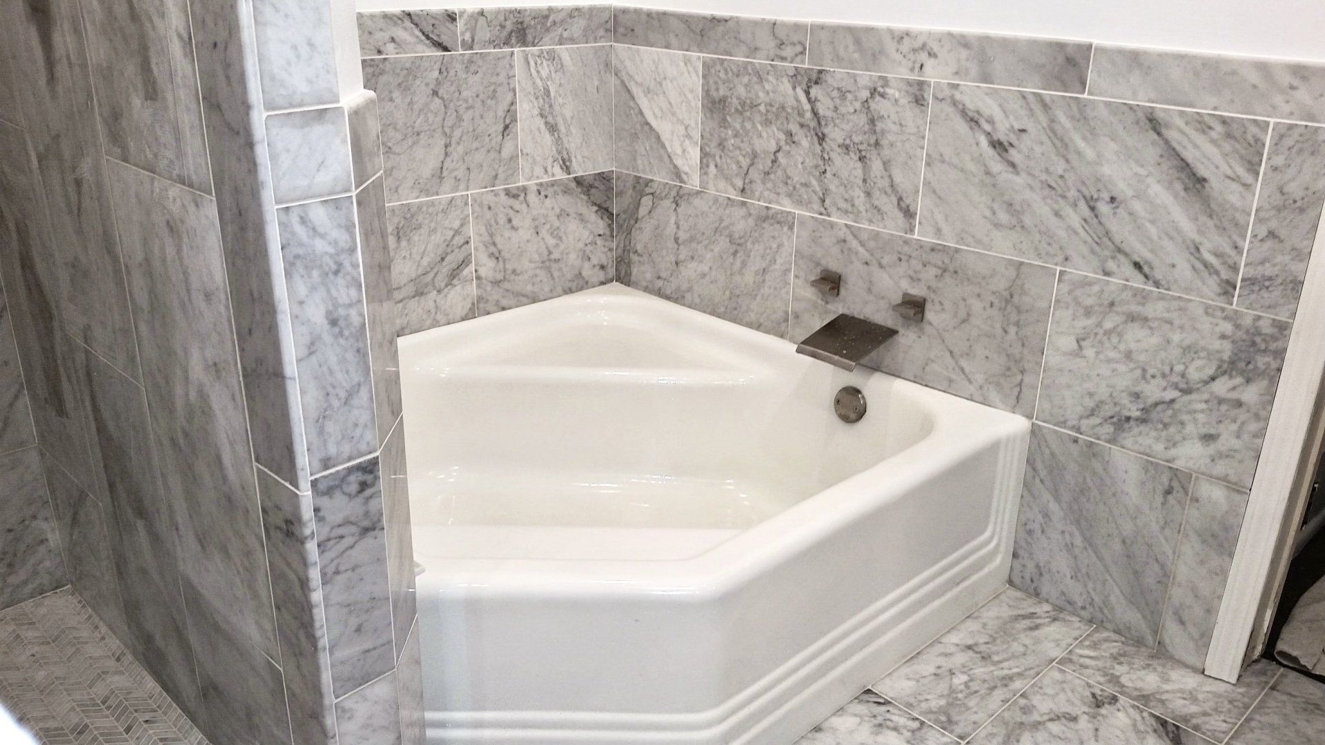 There is a bathtub in the corner of the bathroom.