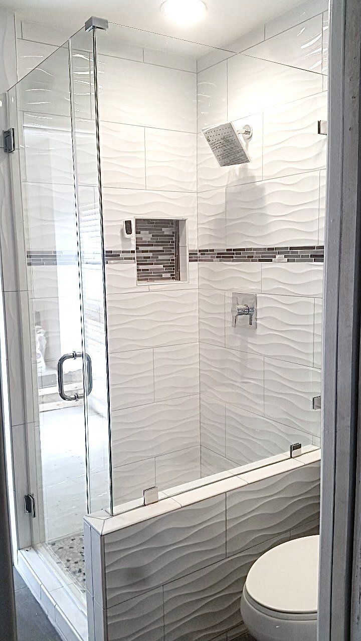 A bathroom with a walk in shower , toilet and bathtub.