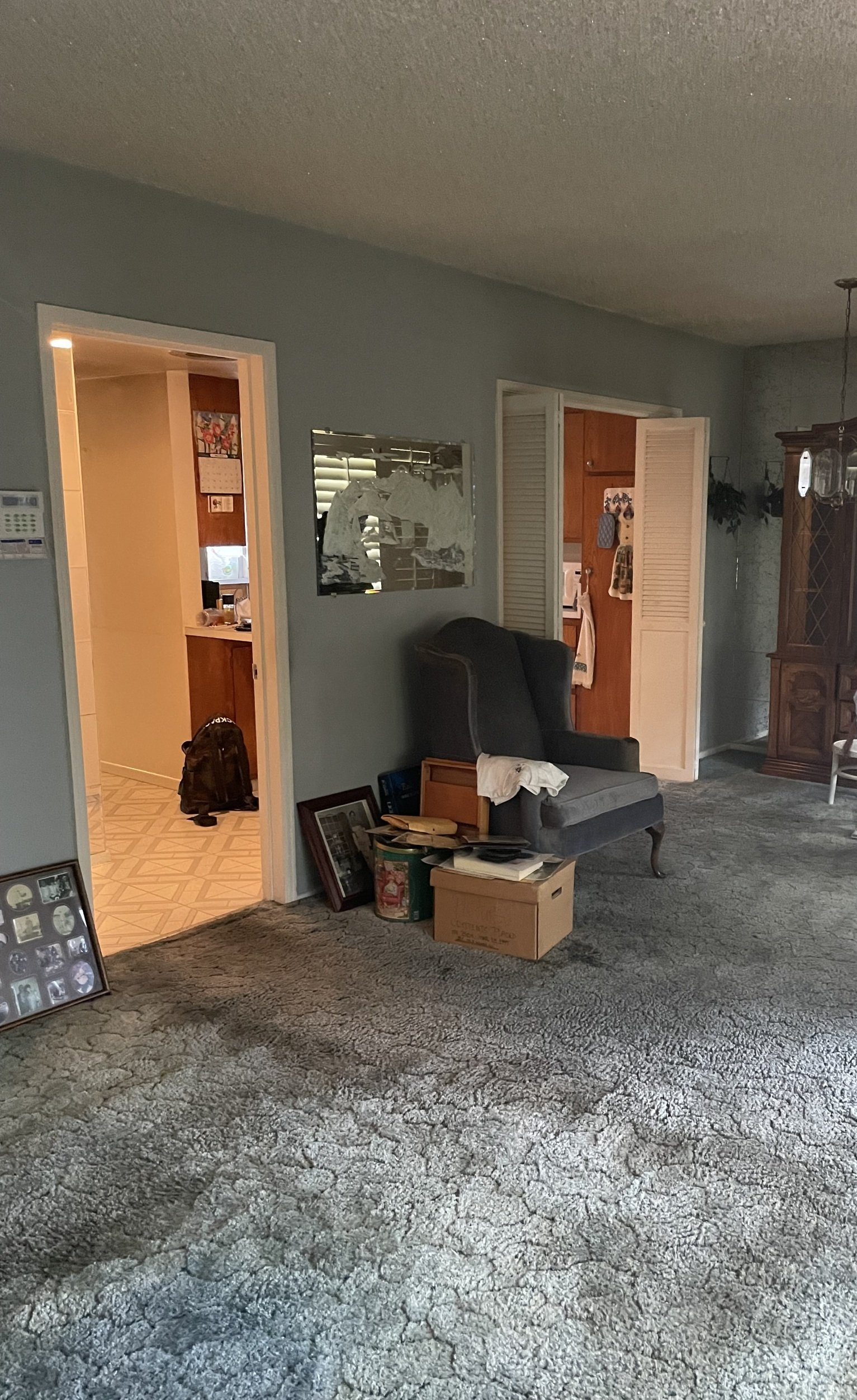 A living room with a couch , chair , and mirror.