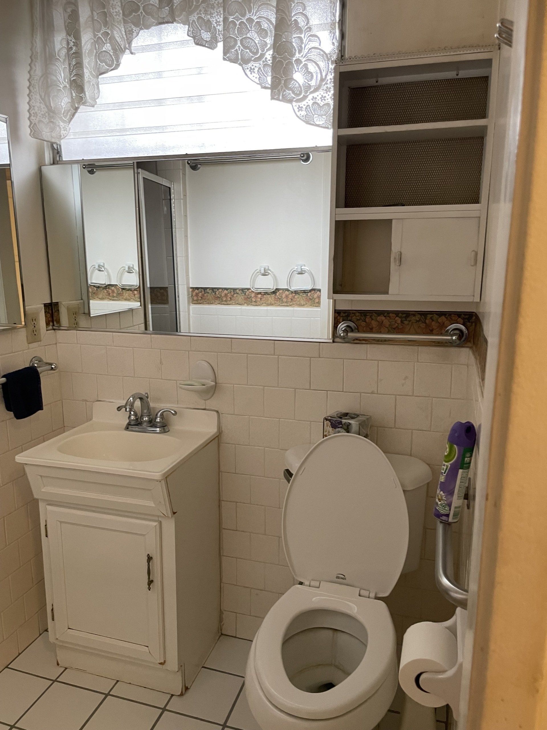 A bathroom with a toilet , sink and mirror