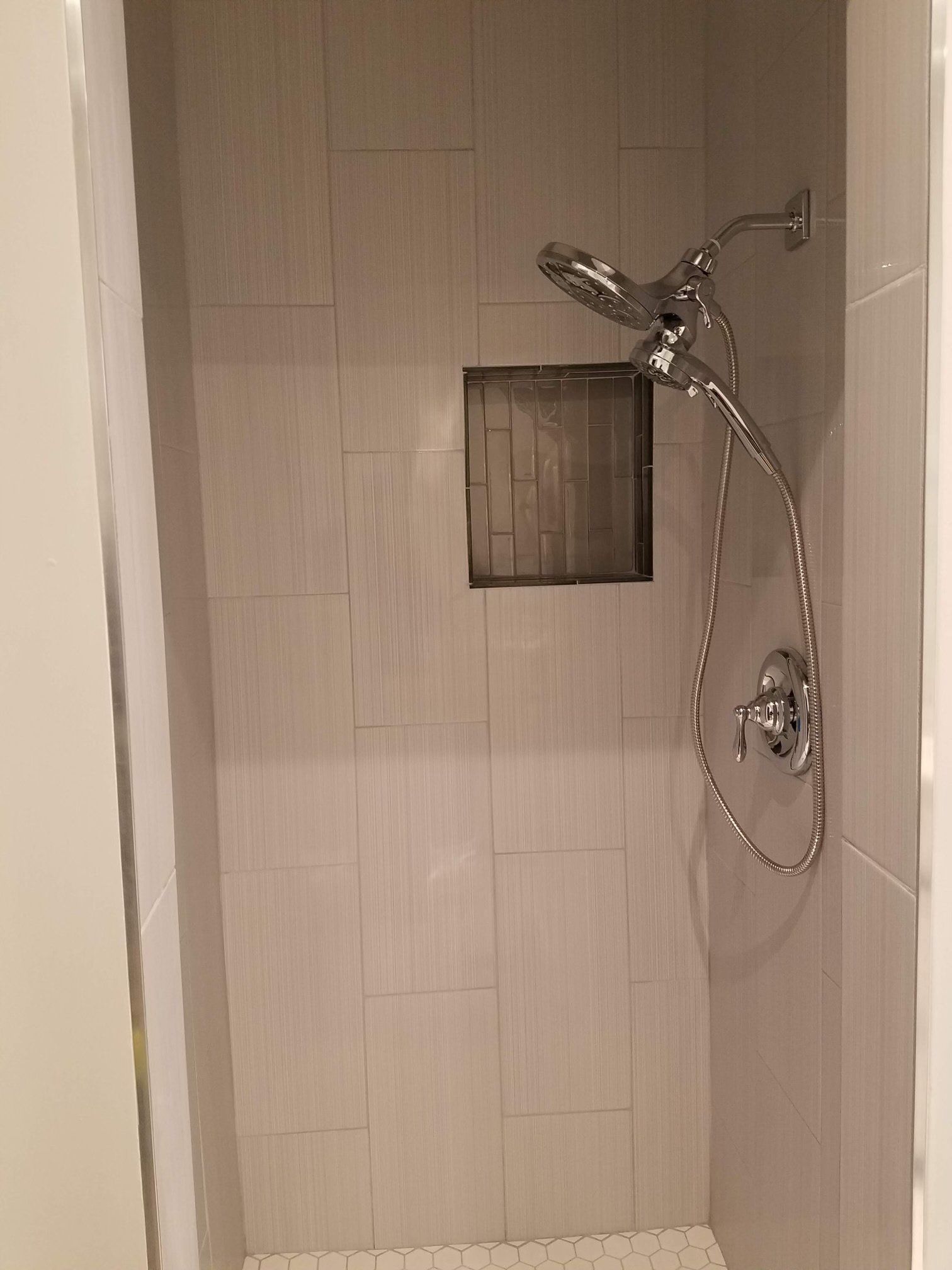 A shower with a shower head attached to the wall.
