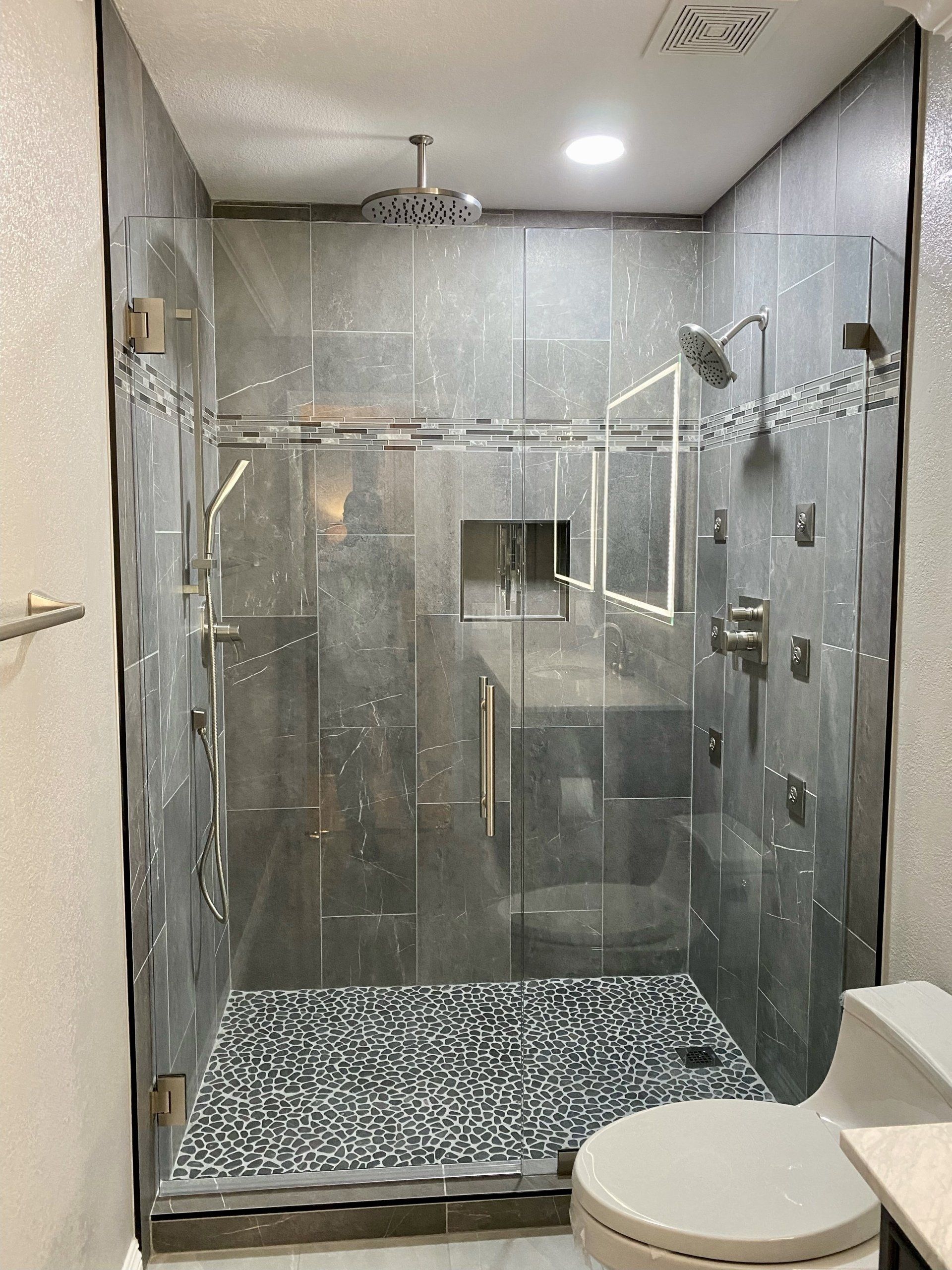 A bathroom with a walk in shower and a toilet.