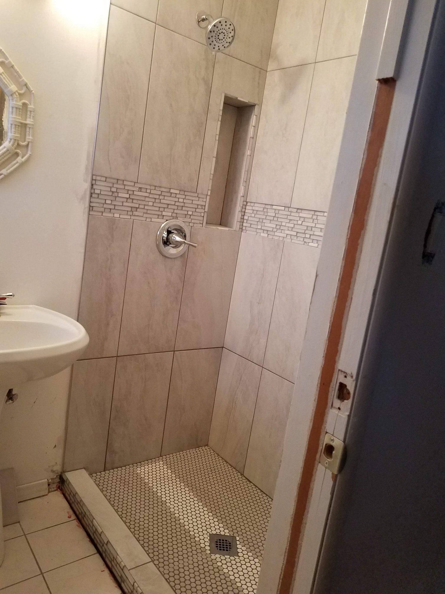 A bathroom with a sink and a walk in shower