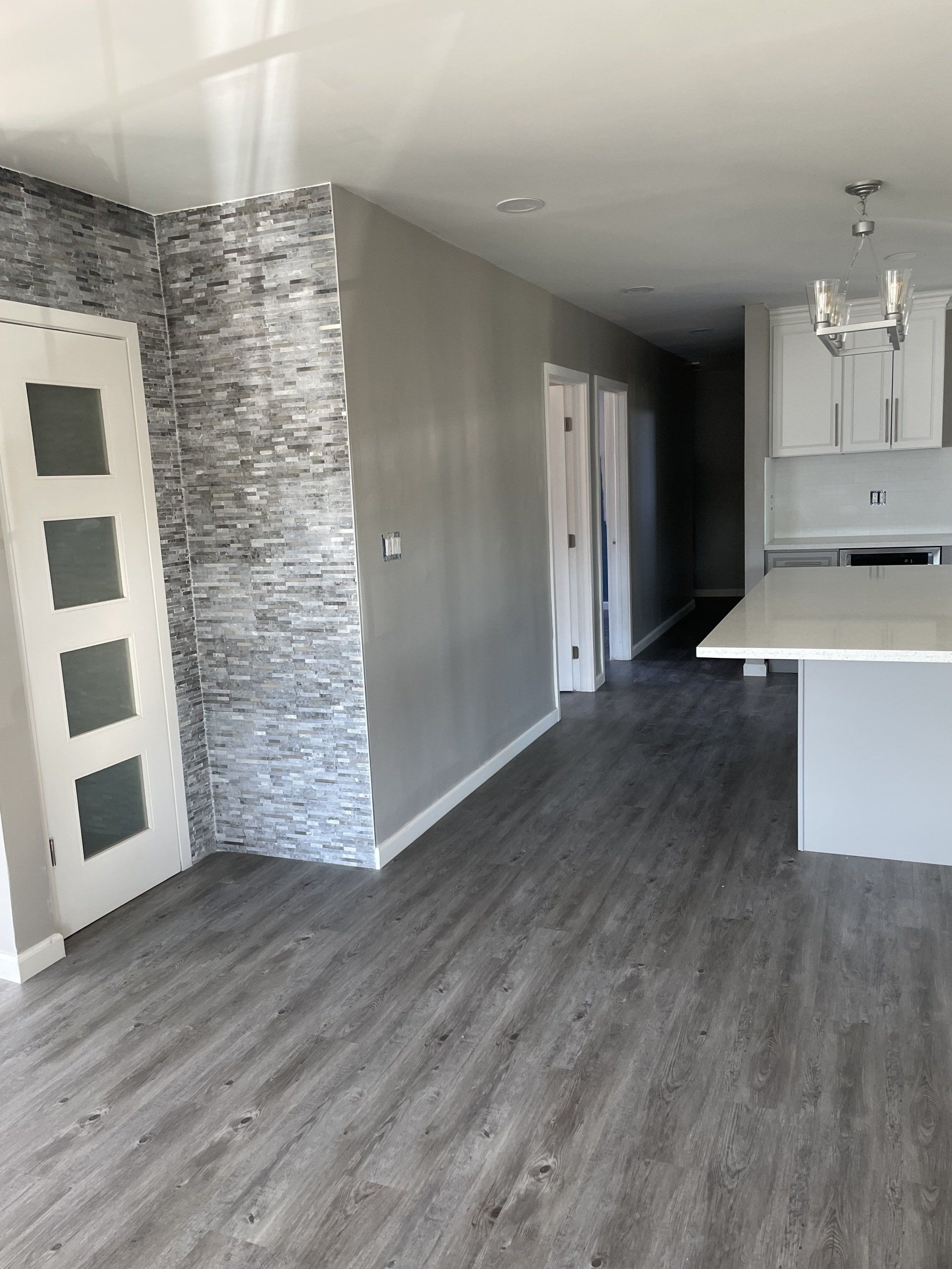 An empty room with a stone wall and a kitchen