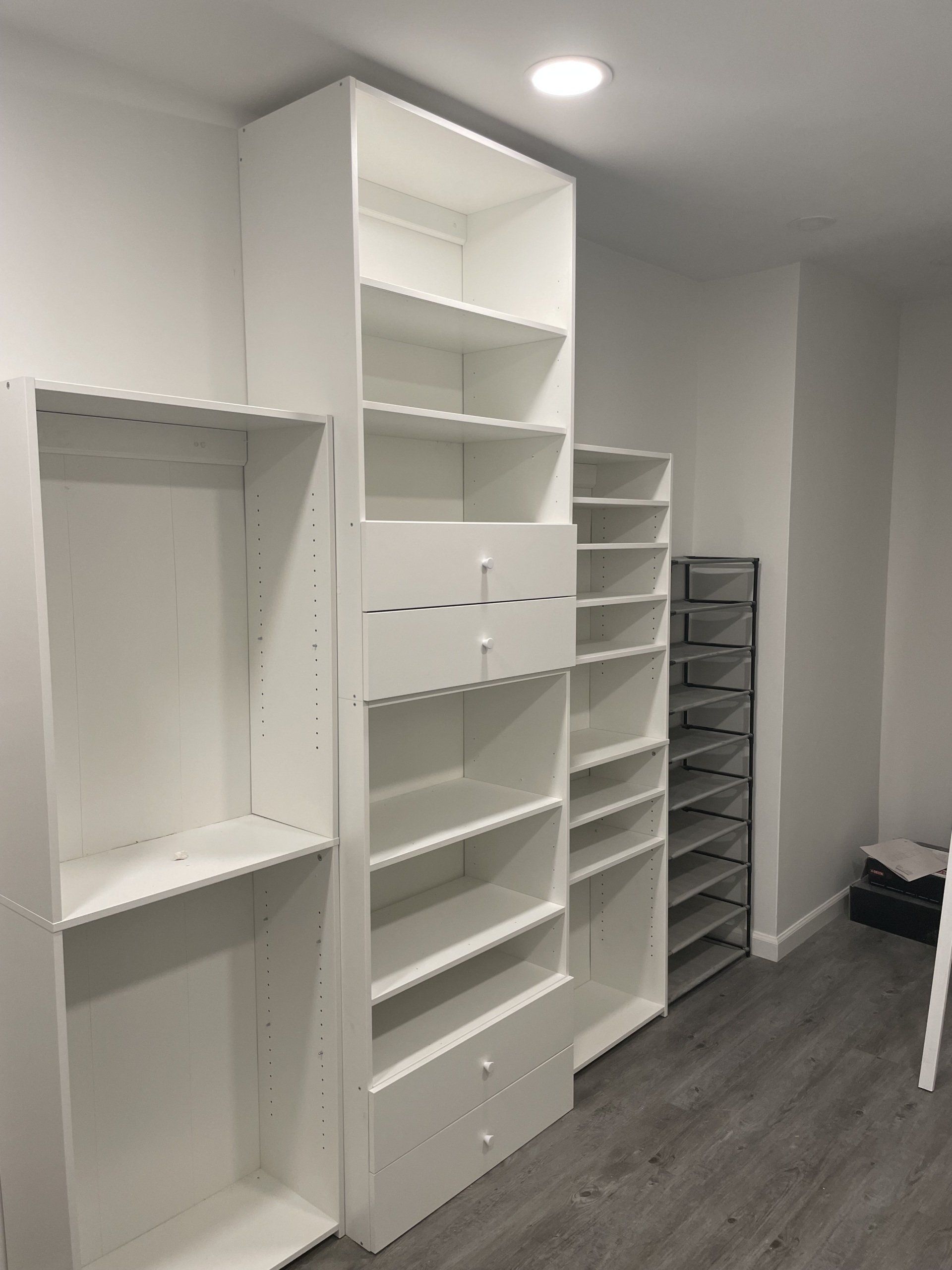 A walk in closet with lots of shelves and drawers.