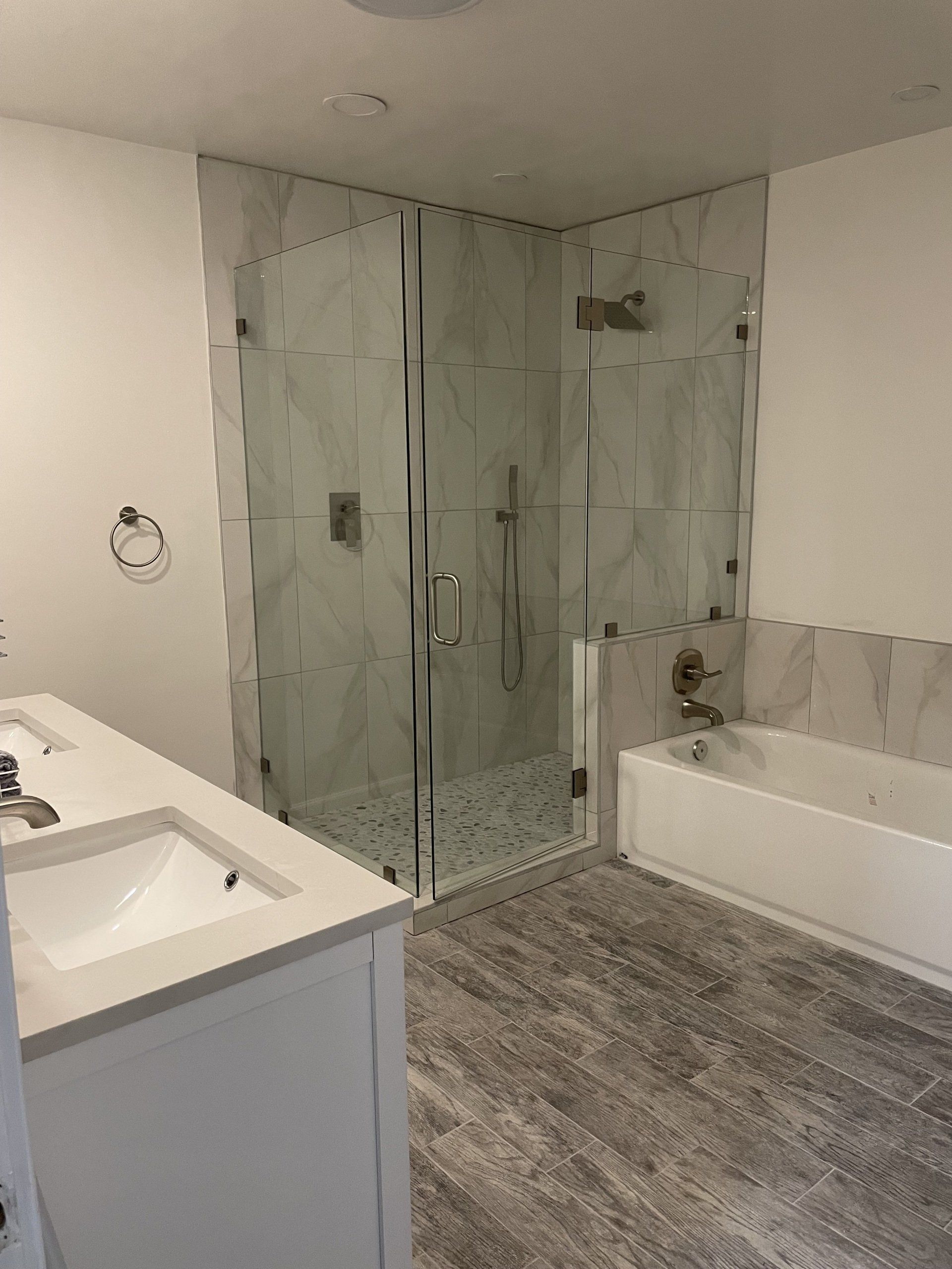 A bathroom with a sink , tub , shower and walk in shower.