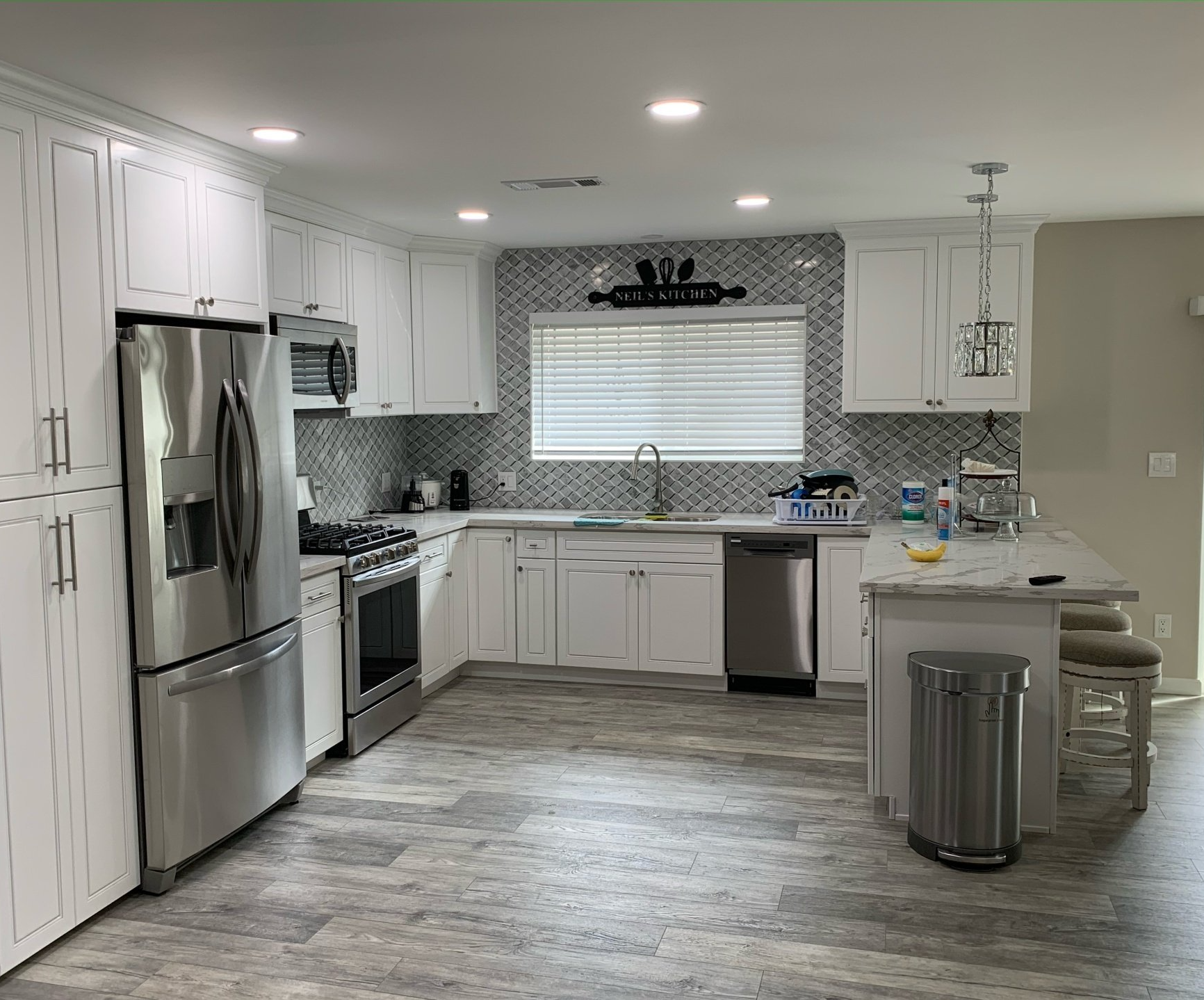 A kitchen with white cabinets and stainless steel appliances