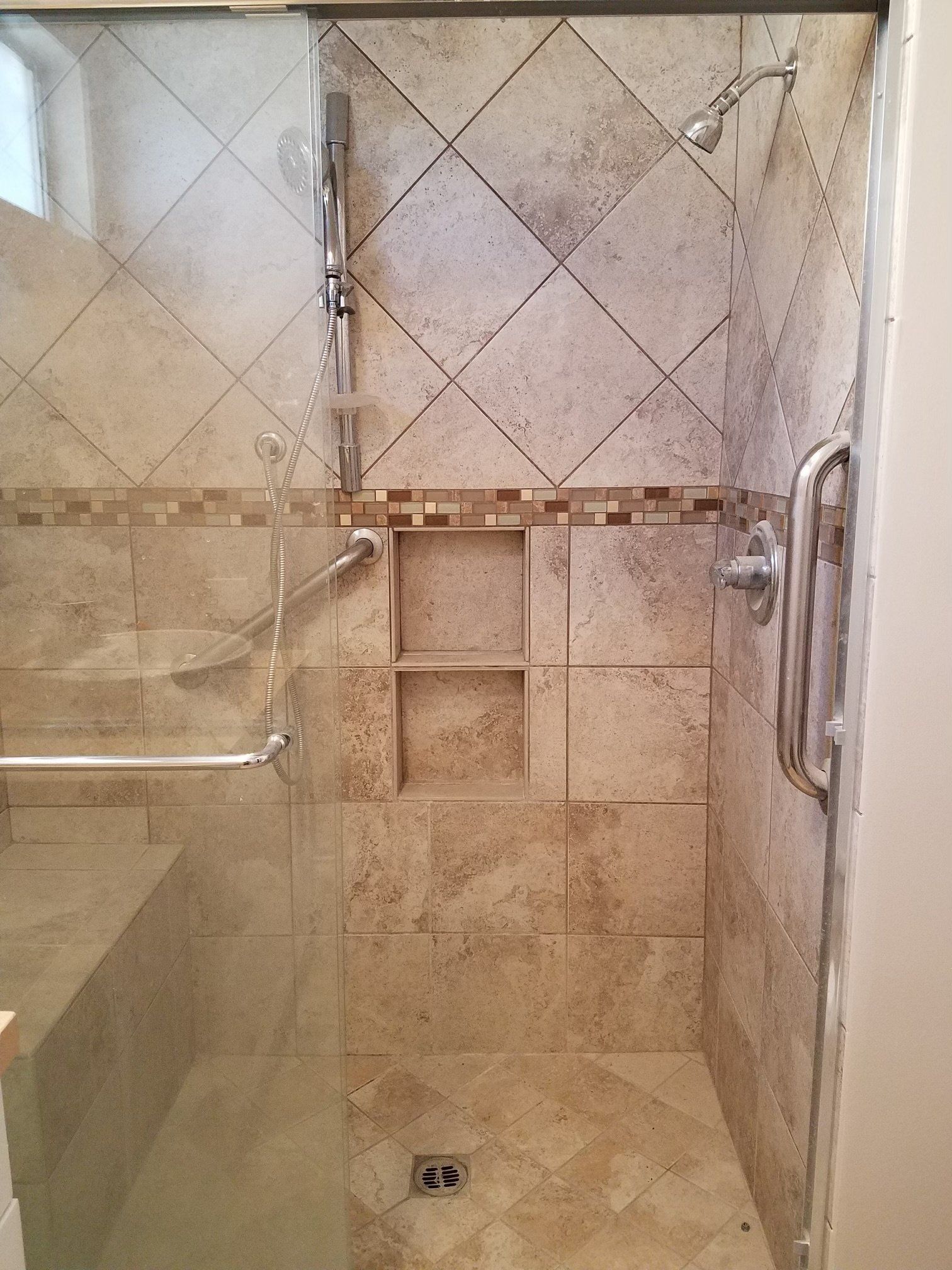 A bathroom with a walk in shower with a glass door