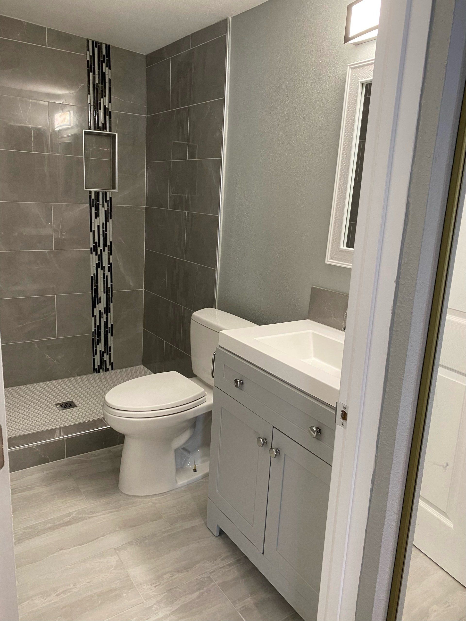 A bathroom with a toilet , sink , and shower.
