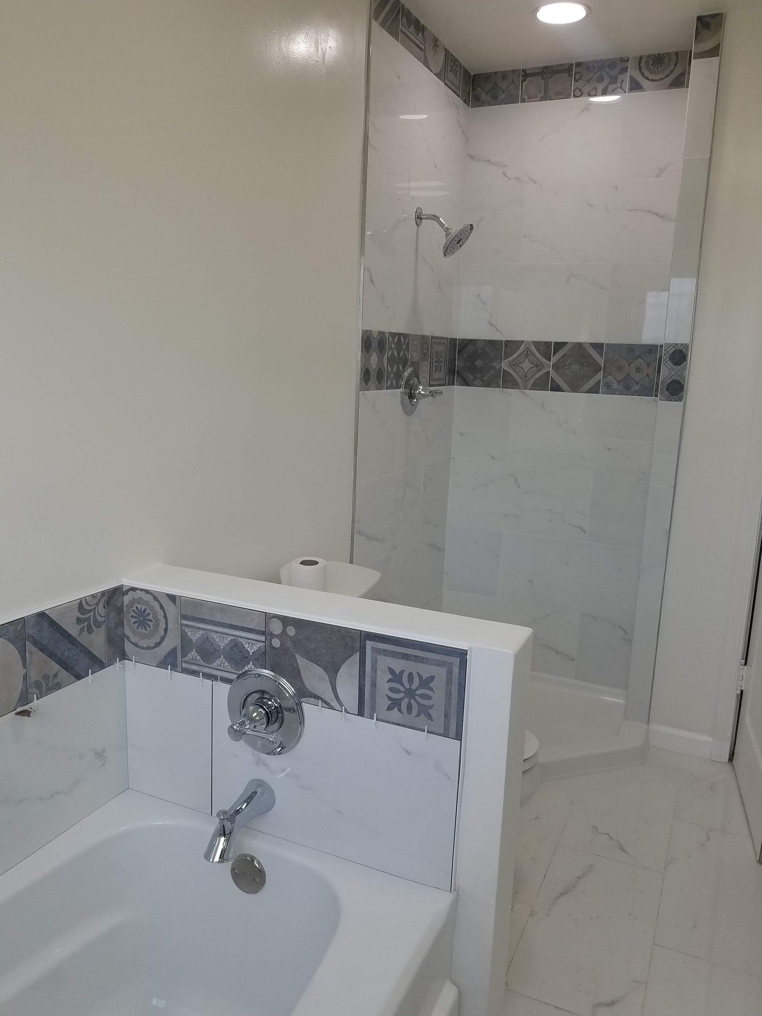 A bathroom with a bathtub and a walk in shower.