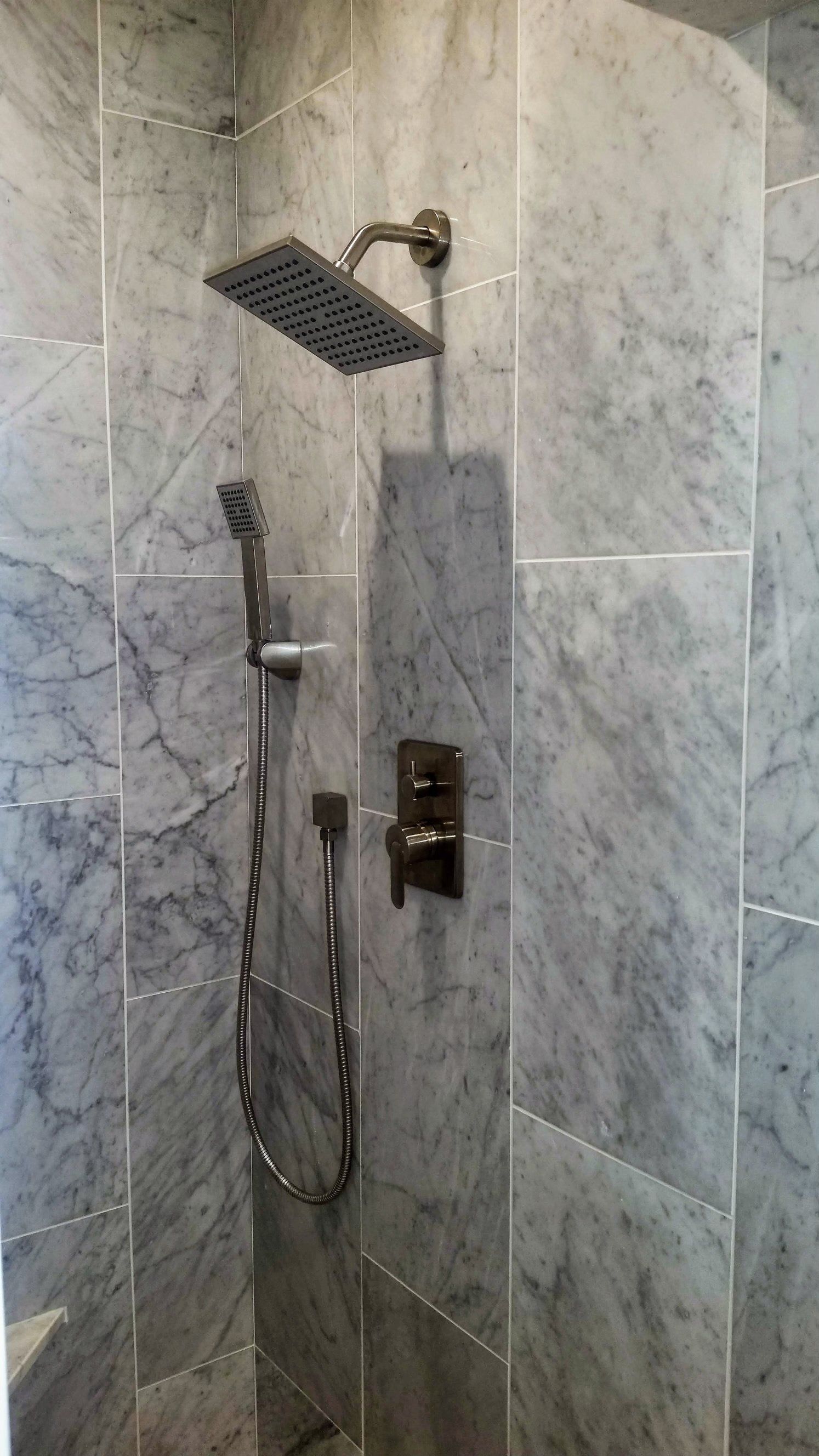 There is a shower head in the corner of the shower.