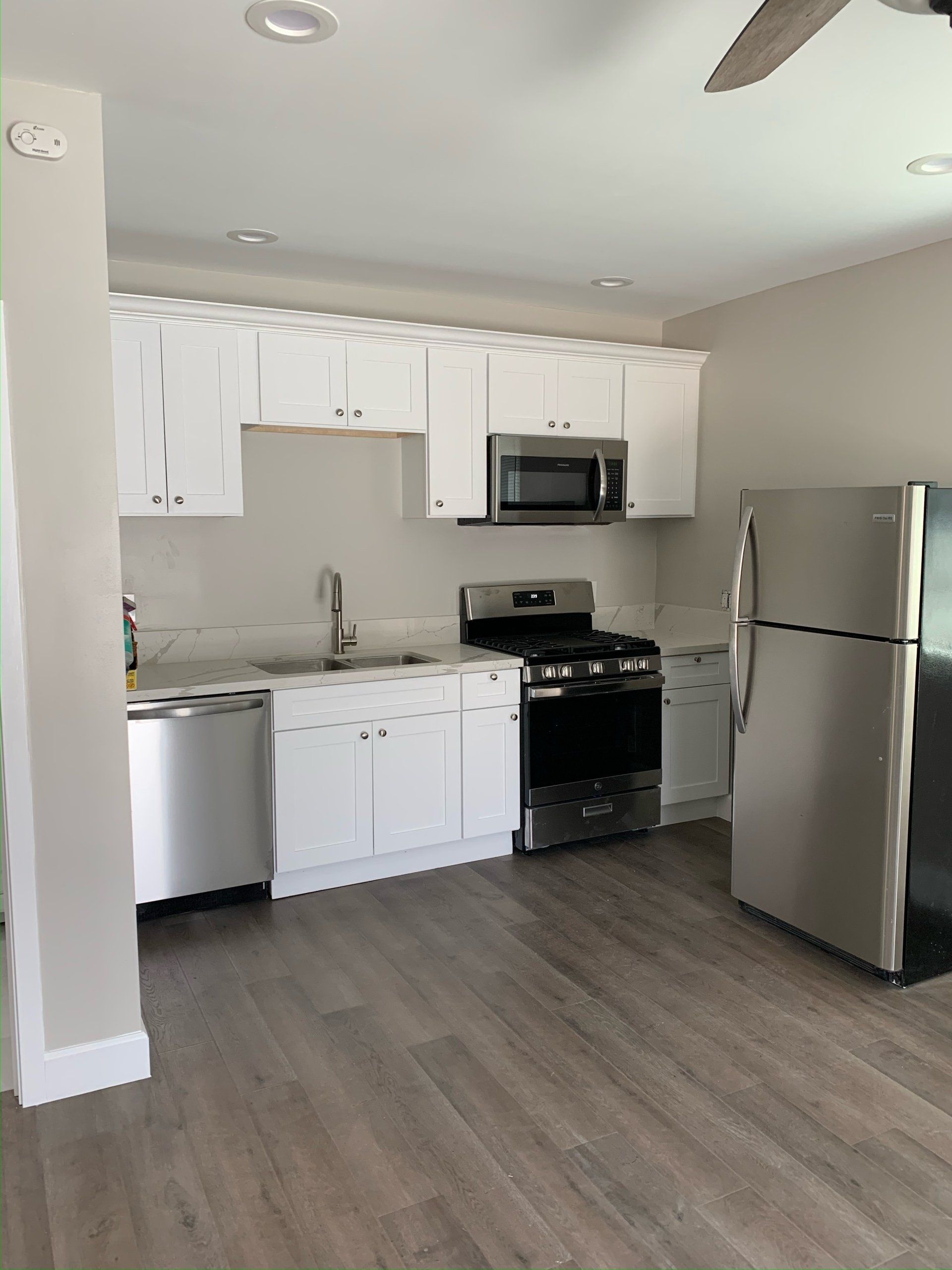 A kitchen with white cabinets and stainless steel appliances