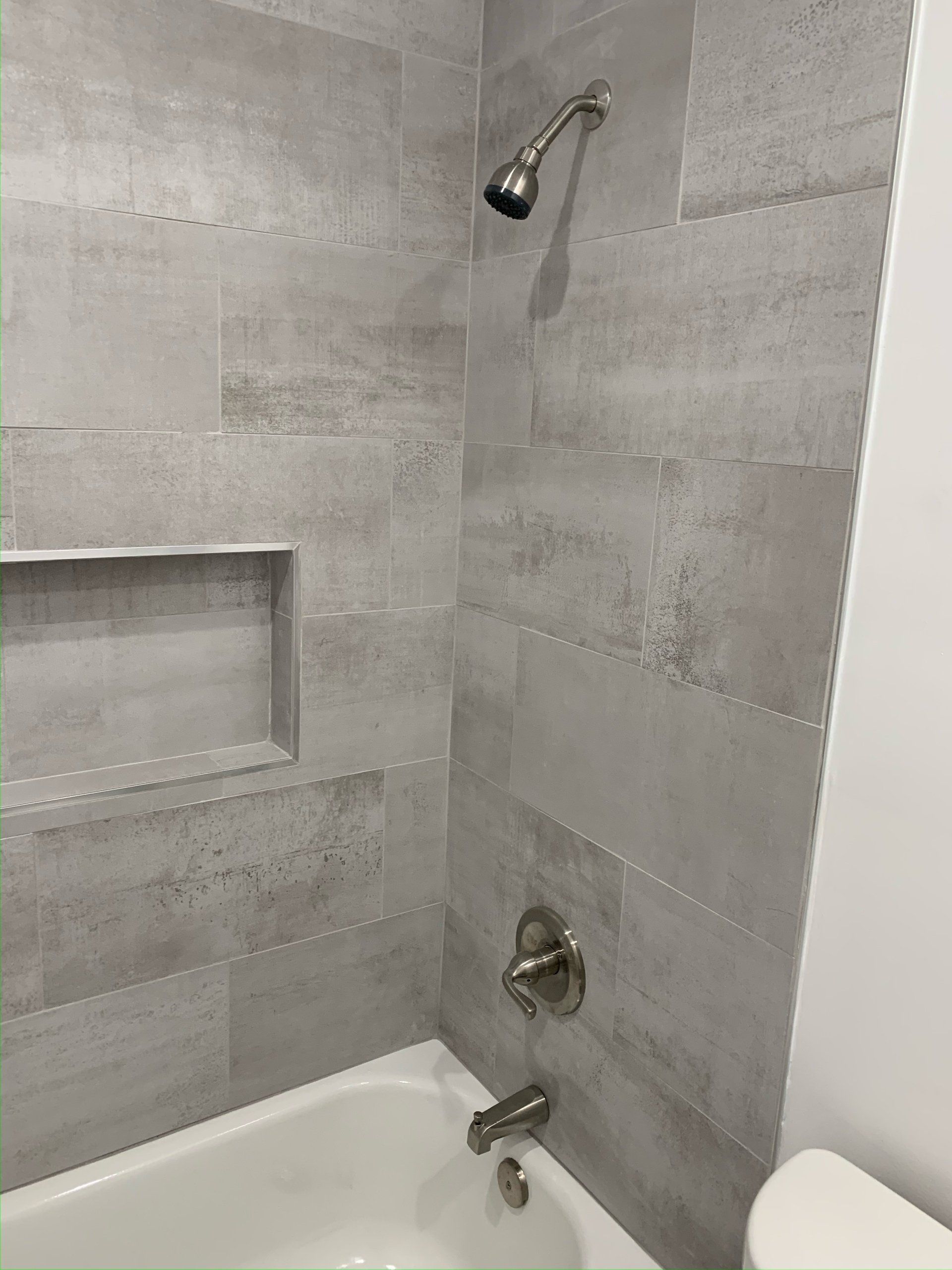 A bathroom with a bathtub , toilet and shower.