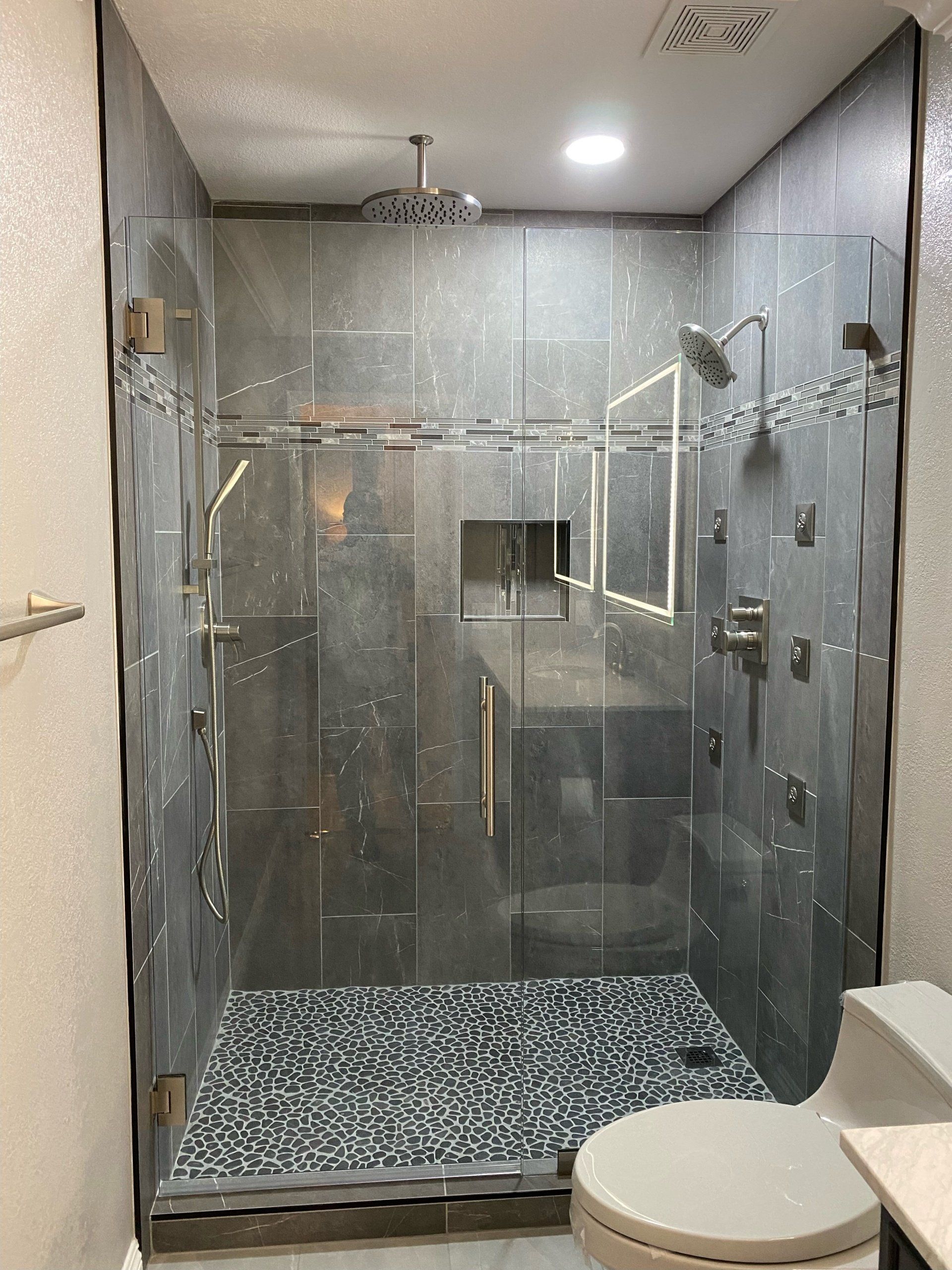 A bathroom with a walk in shower and a toilet.