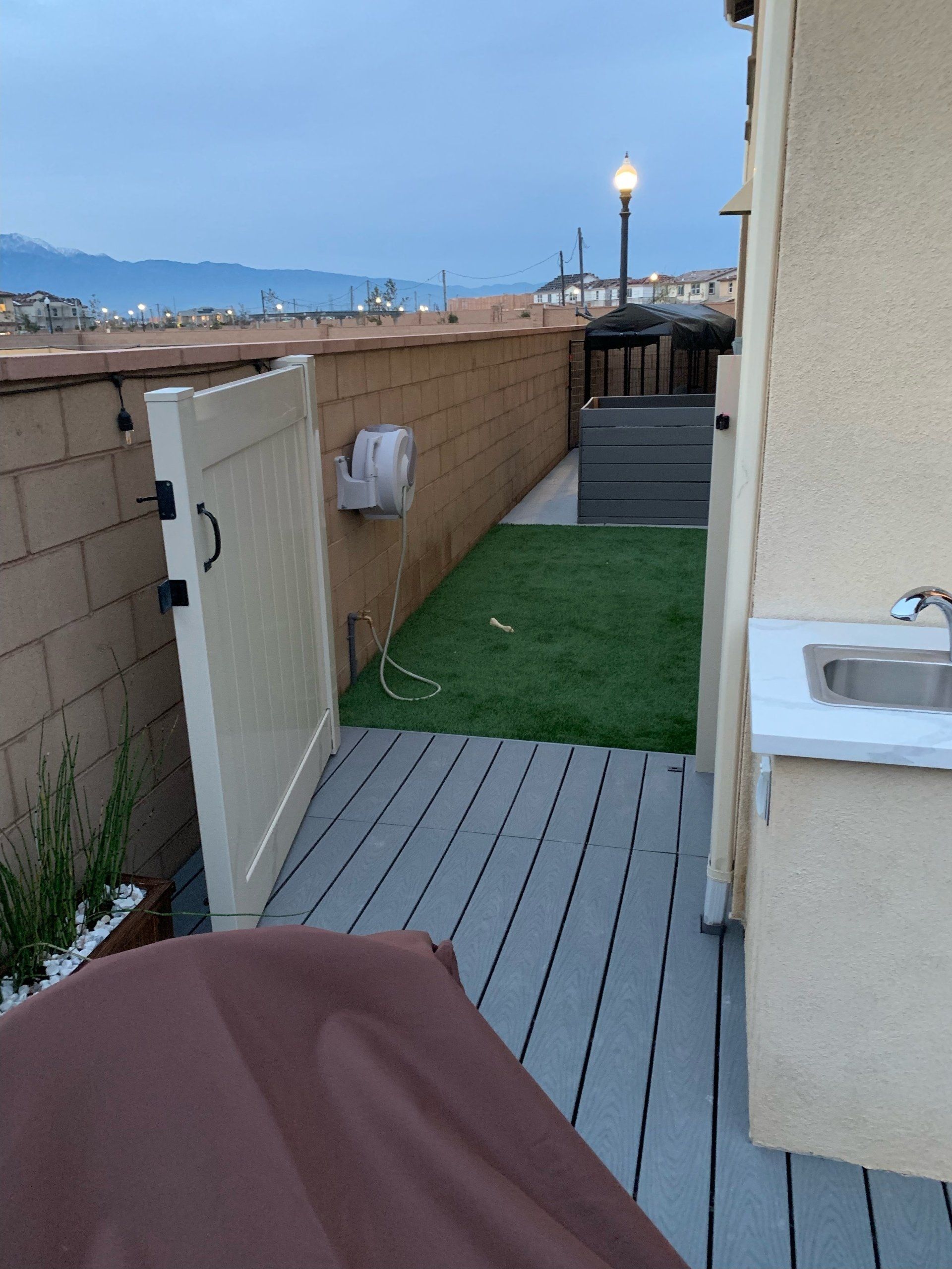 A white gate leads to a fenced in yard
