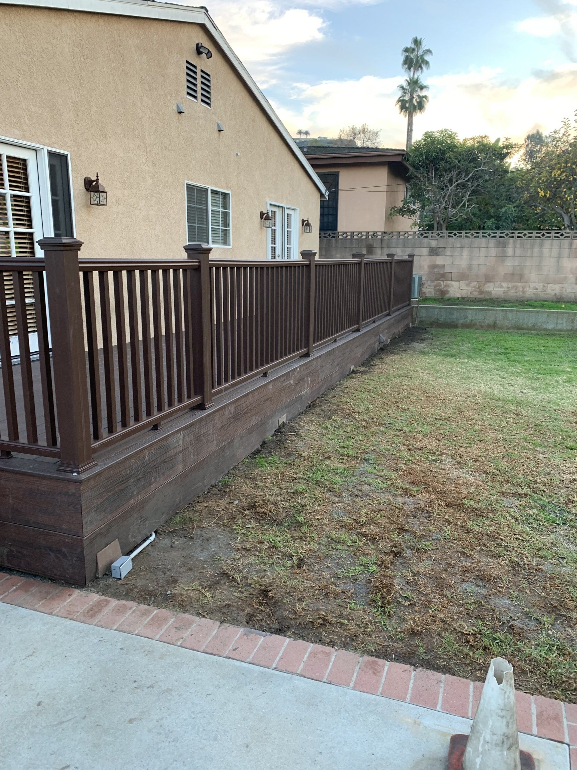 A house with a wooden deck and fence in front of it