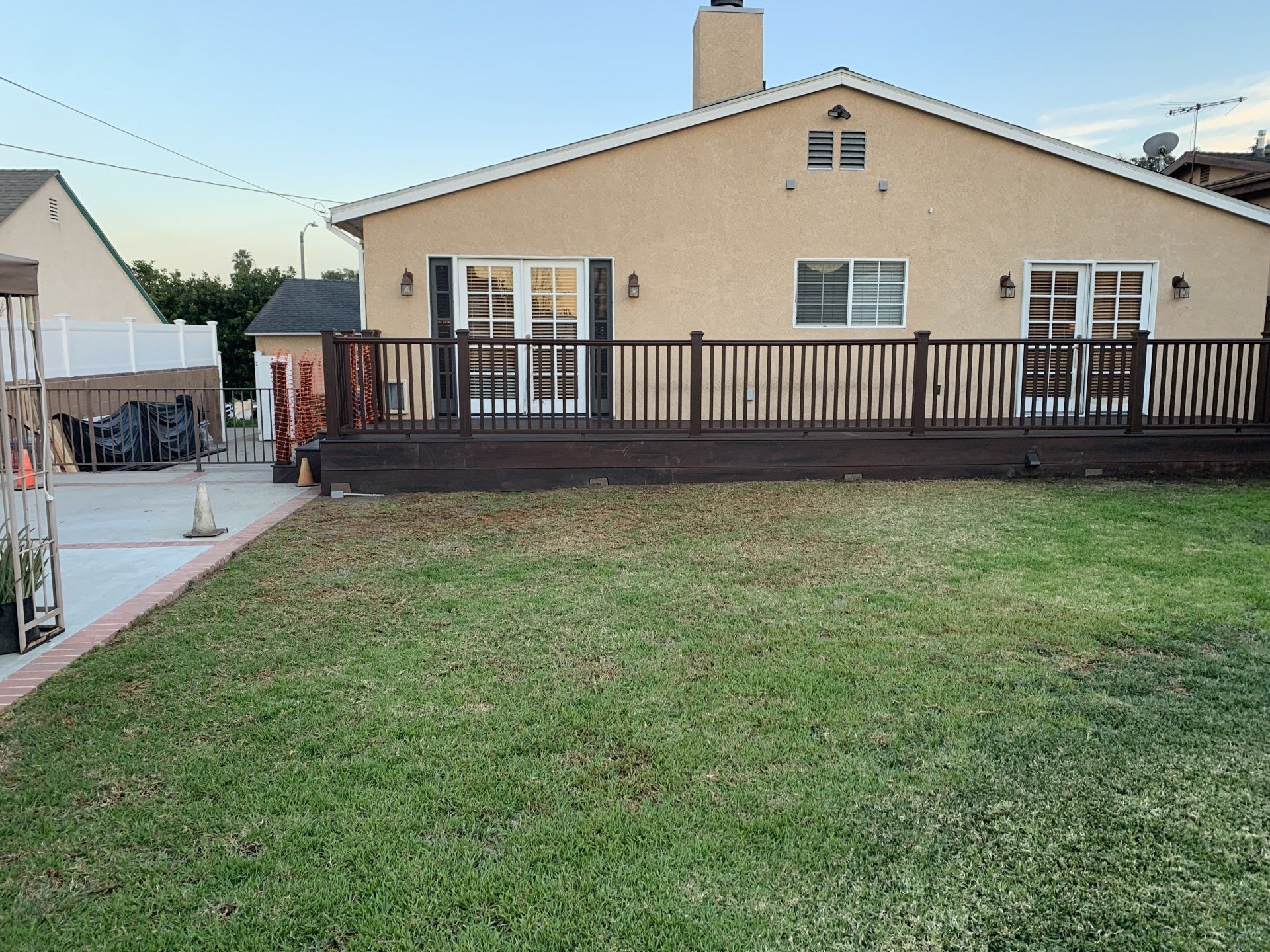 A house with a deck and a large lawn in front of it