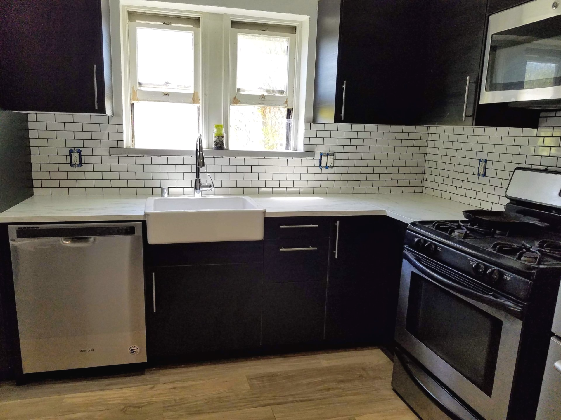 A kitchen with black cabinets and stainless steel appliances