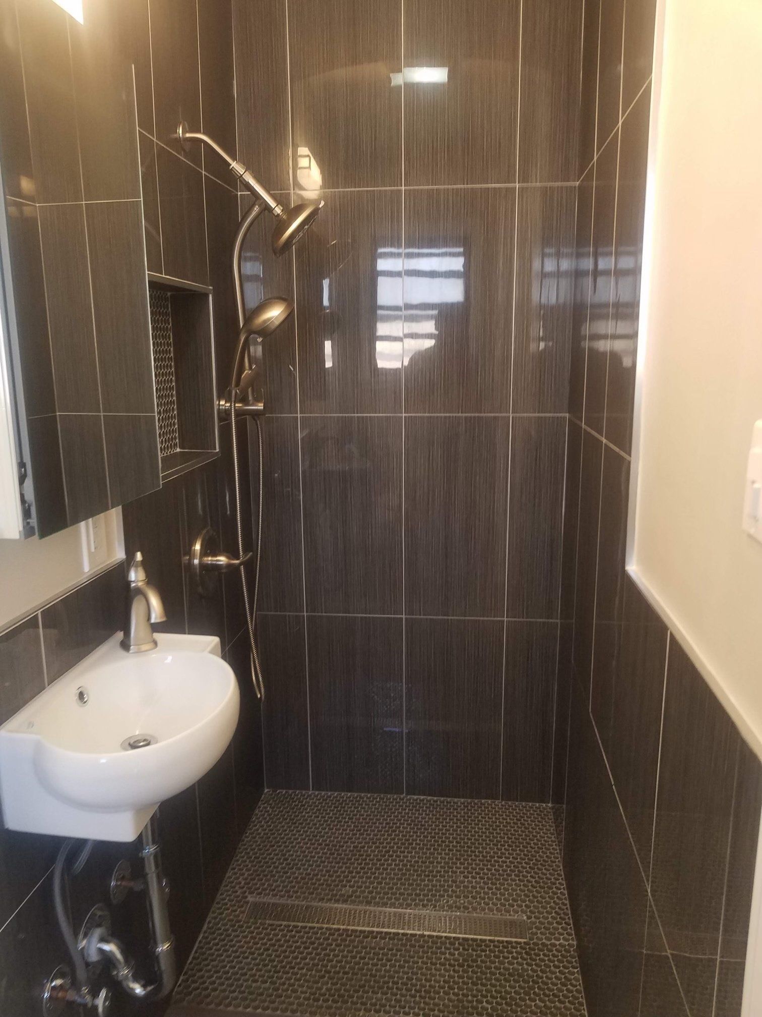 A bathroom with a sink and a walk in shower