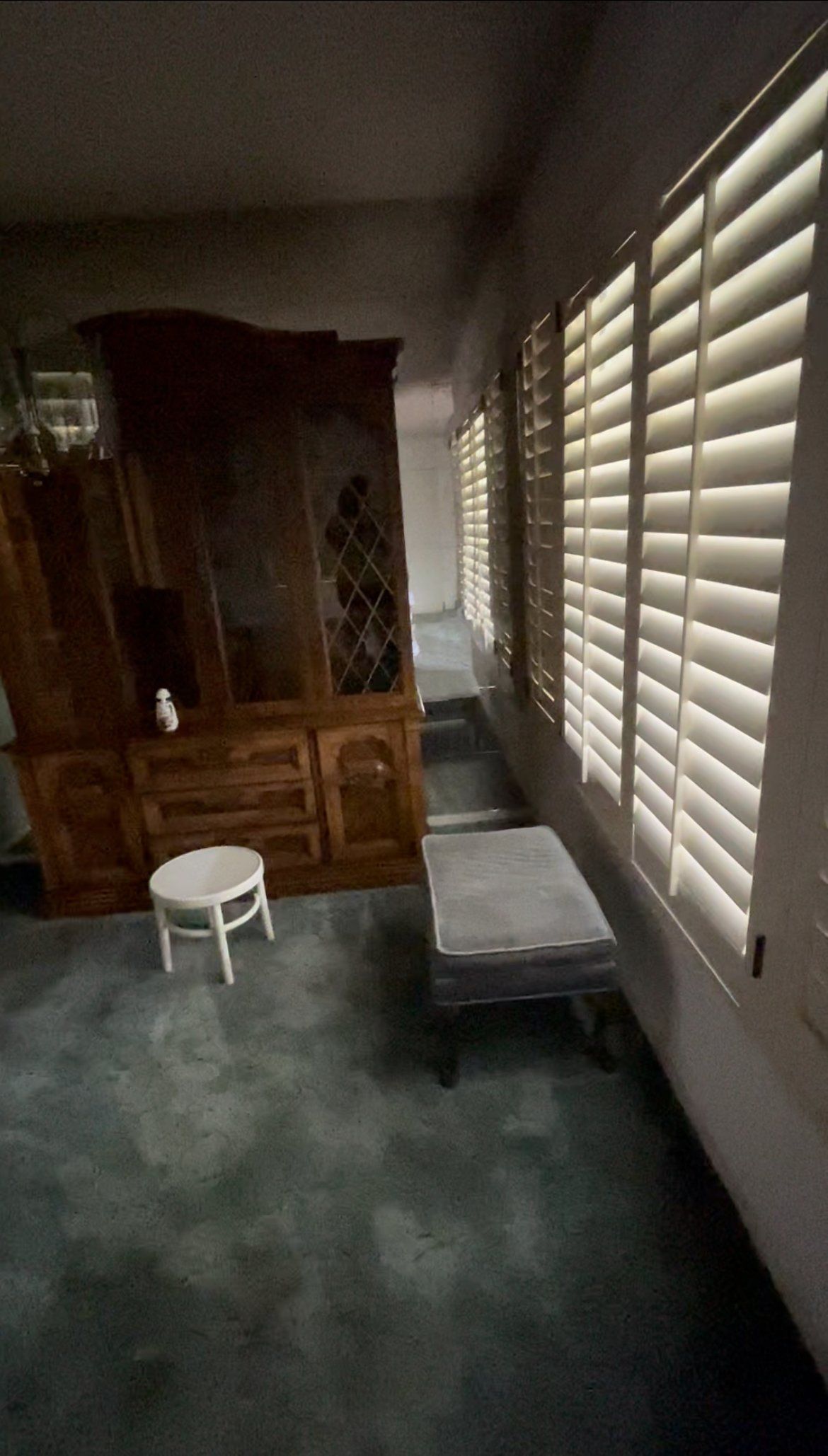 A room with a lot of windows and shutters on the windows.