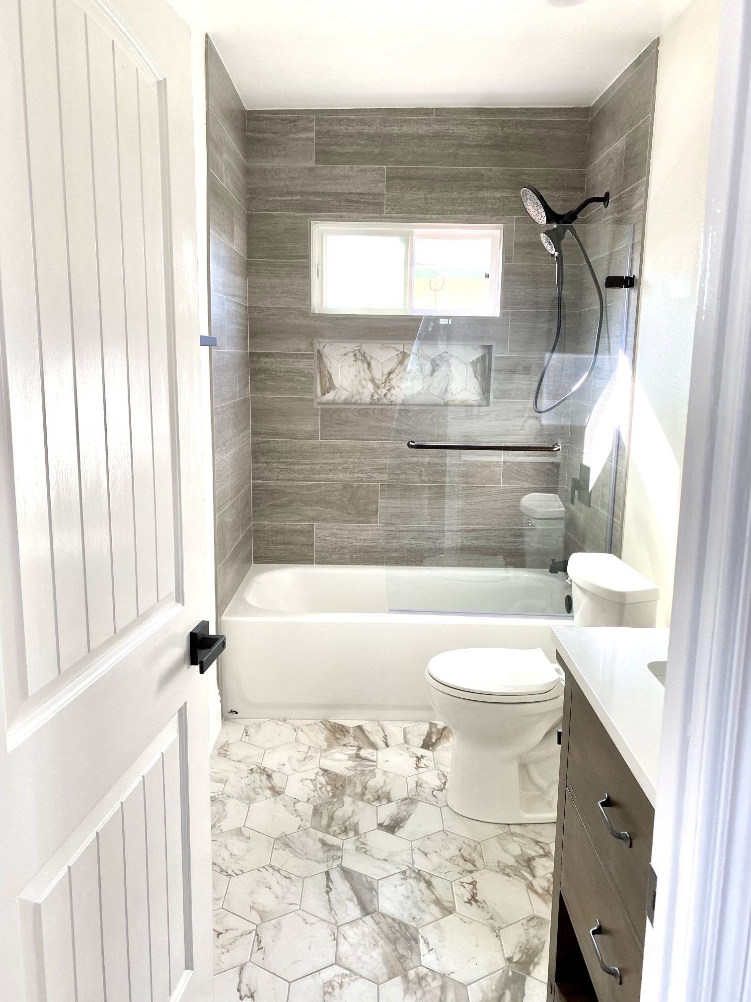 A bathroom with a tub , toilet , sink and shower.