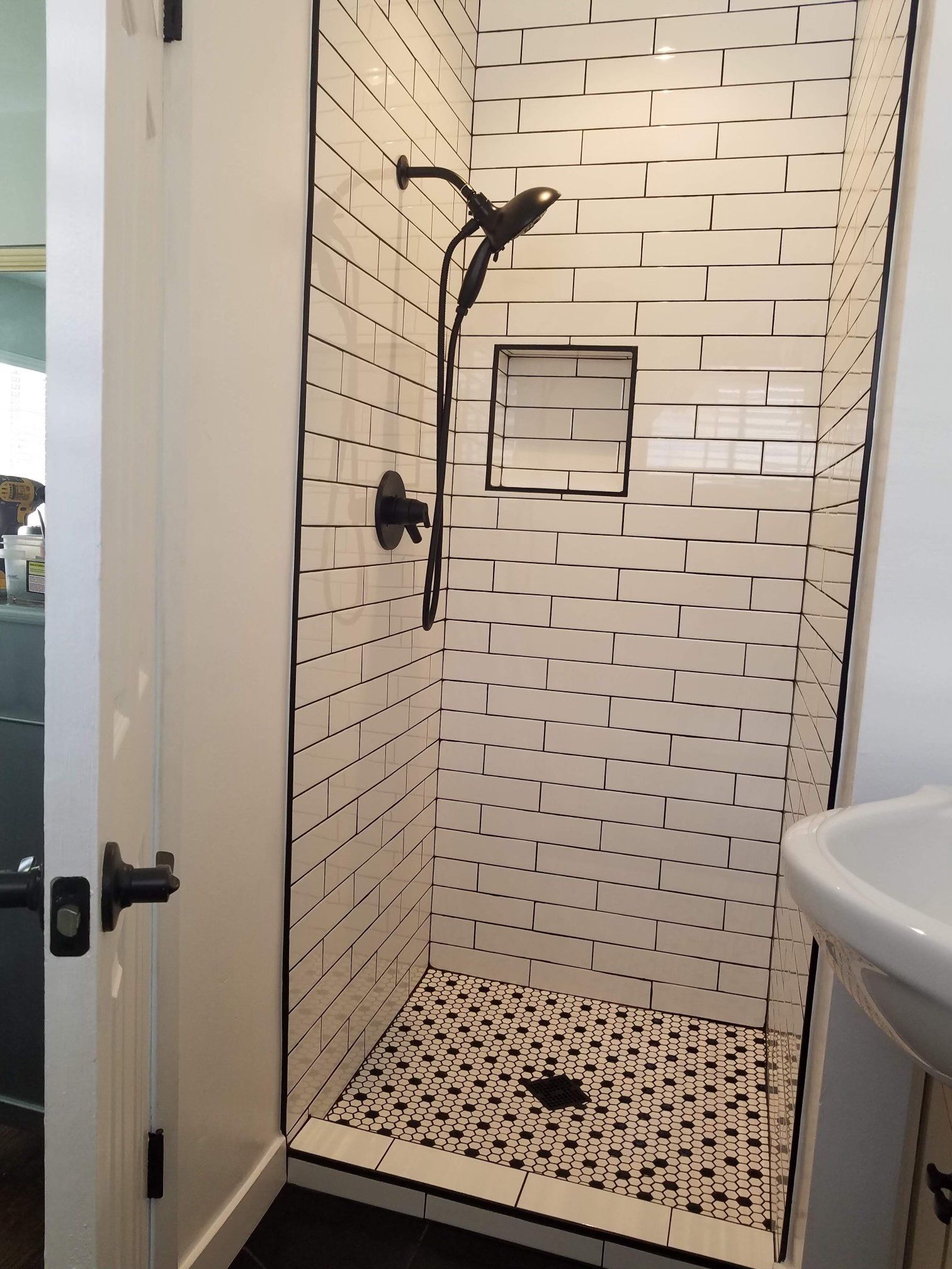 A bathroom with a walk in shower and a sink