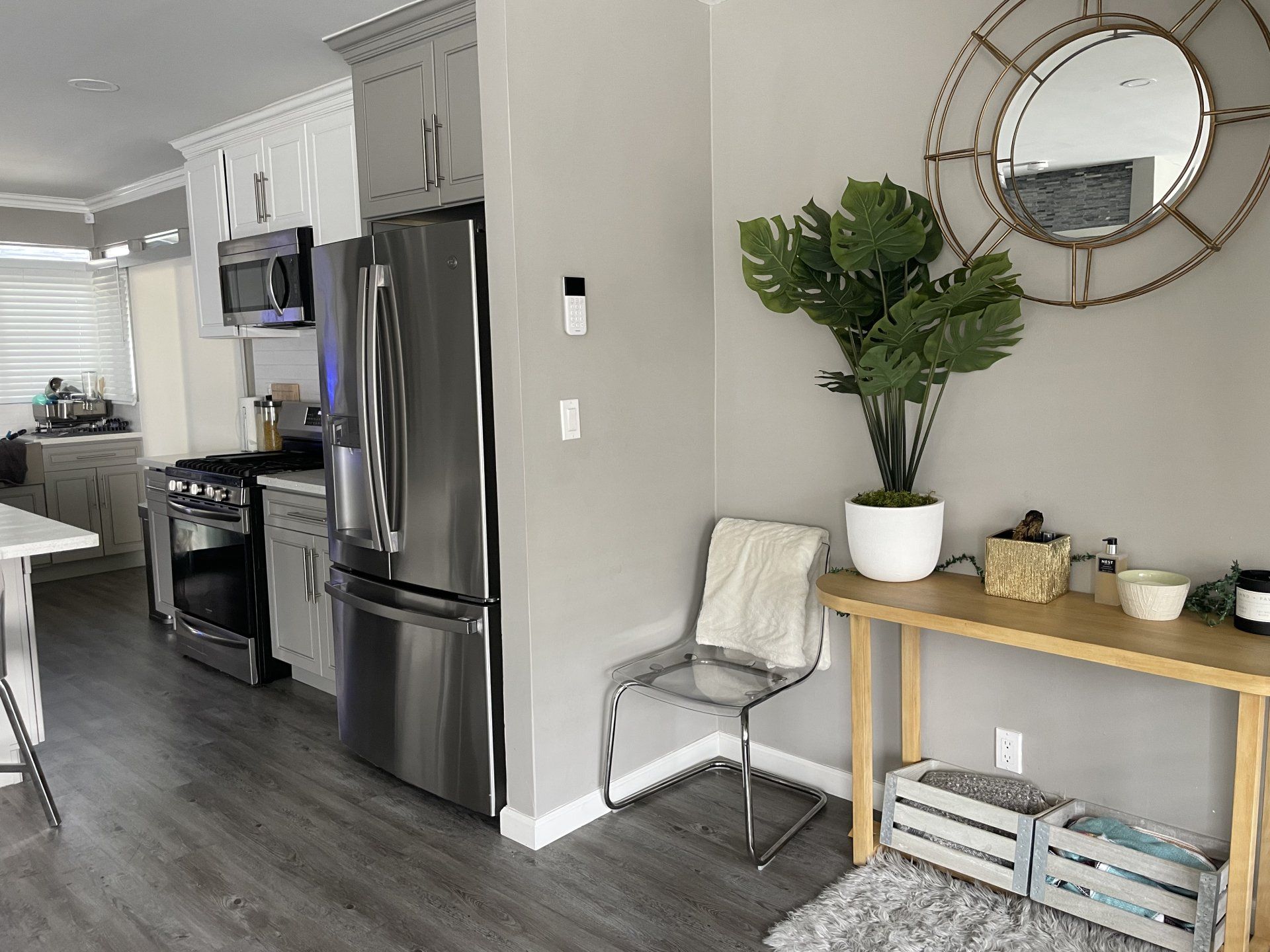 A kitchen with stainless steel appliances and a clock on the wall.