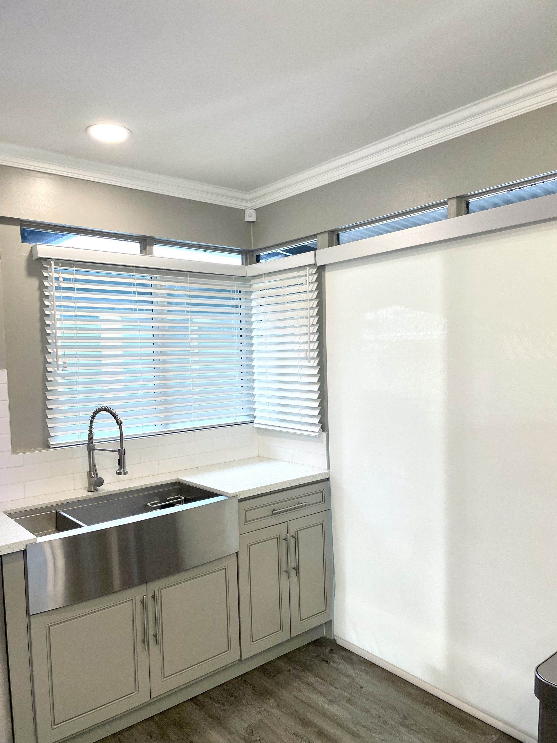 A kitchen with stainless steel cabinets , a sink , and a window.