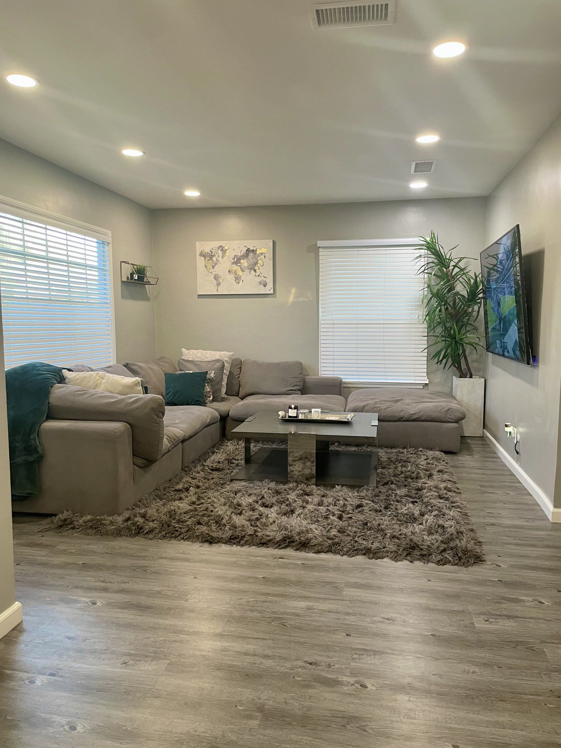 A living room with a couch , coffee table , rug and television.