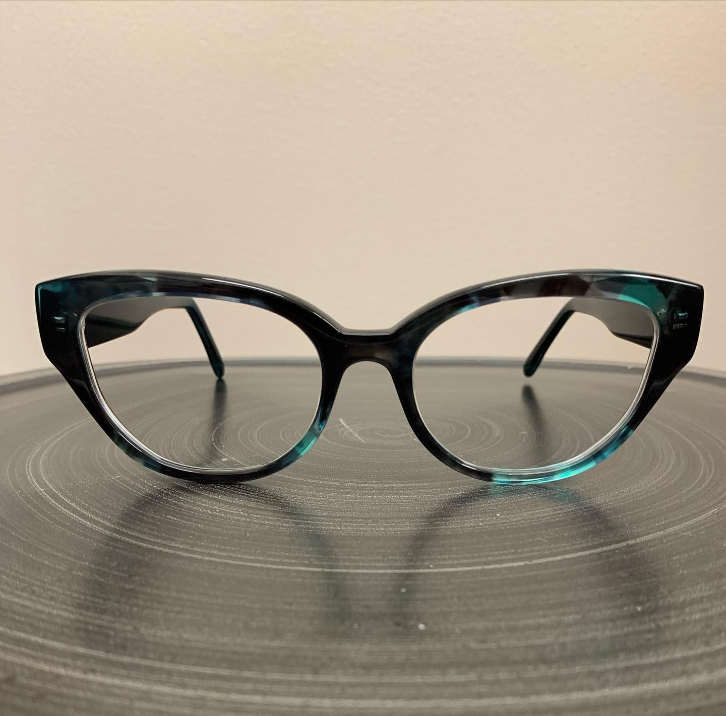 A pair of cat eye glasses are sitting on a table
