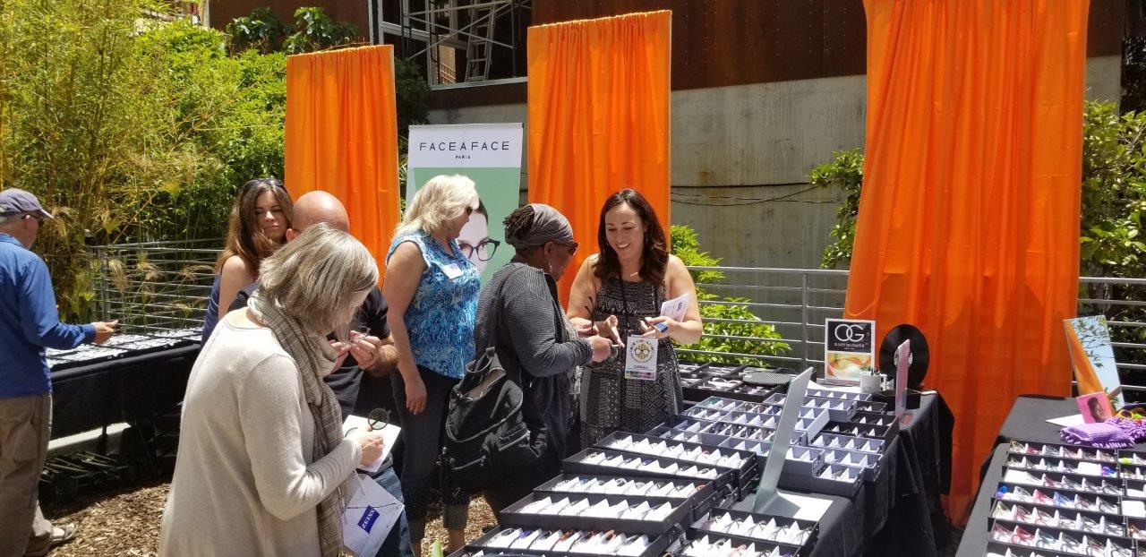 Guest and vendor chatting about frames at Raise Your Glasses 2019 Event