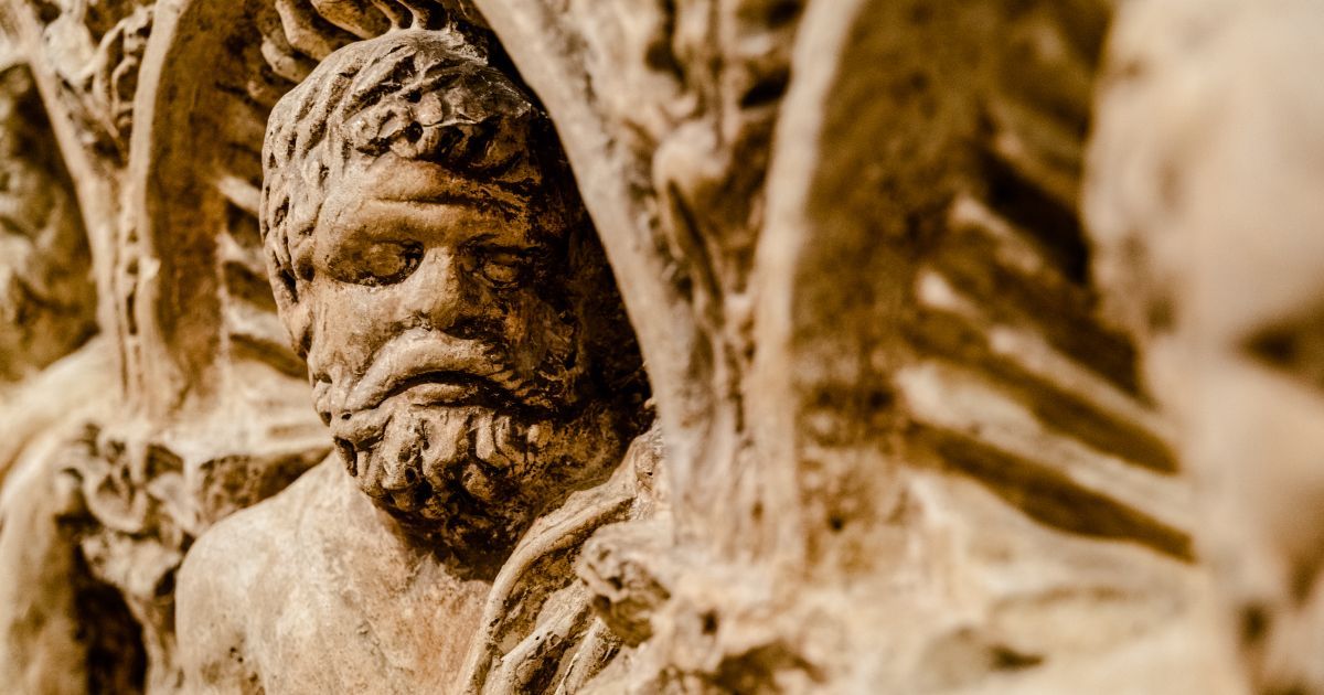 A close up of a statue of a man with a beard carved in medieval stone in the castle of Bari.