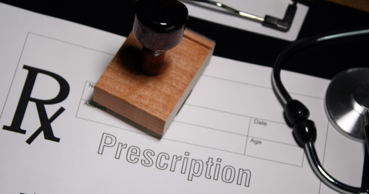 A prescription with a stamp on it and a stethoscope.