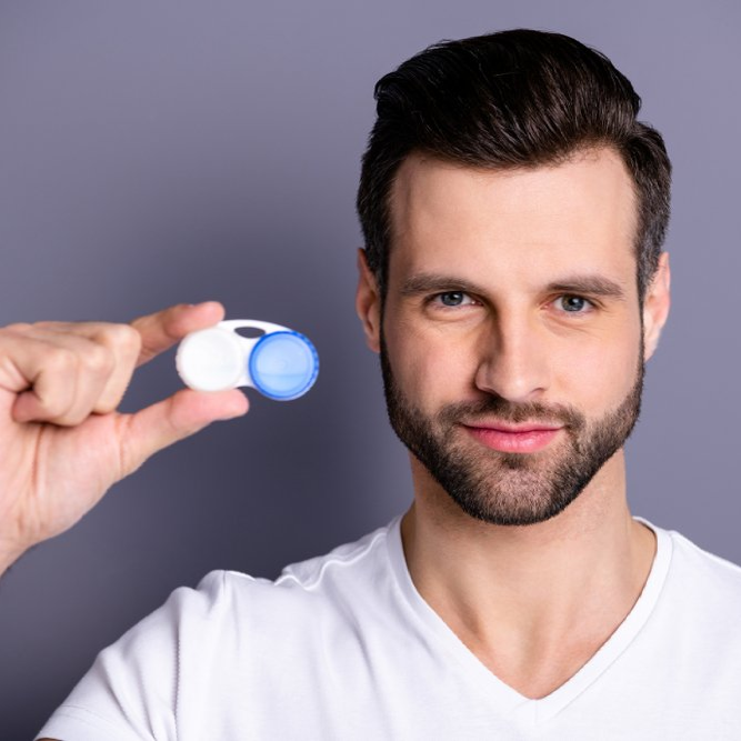 Man with a beard holding up a contact lens case