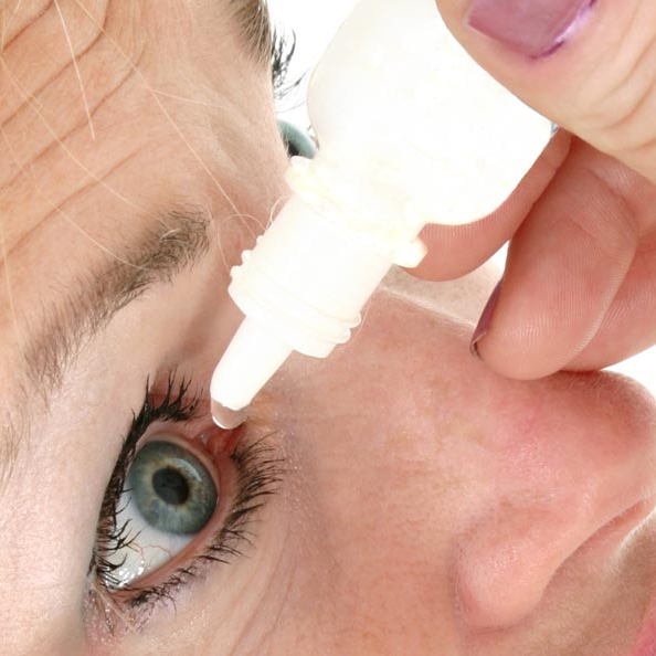 Close up of a woman placing lubricating drops in her right eye