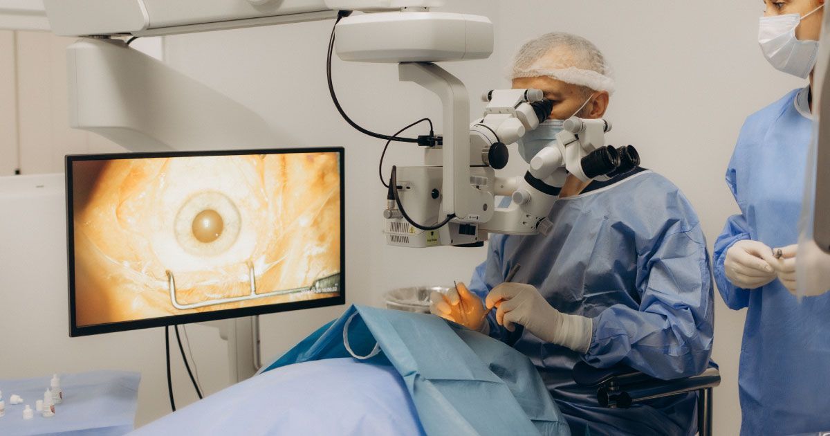 A surgeon is operating on a patient's eye in an operating room.