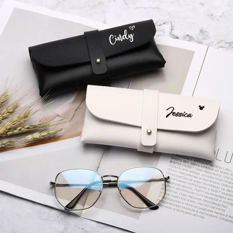 Two personalized eyeglass cases in white and blavk with names en