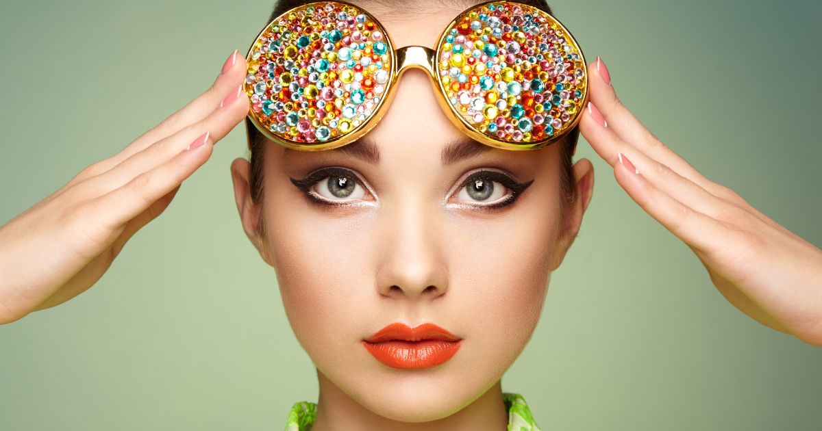 A woman wearing sunglasses woth colorful sprinkles on them.