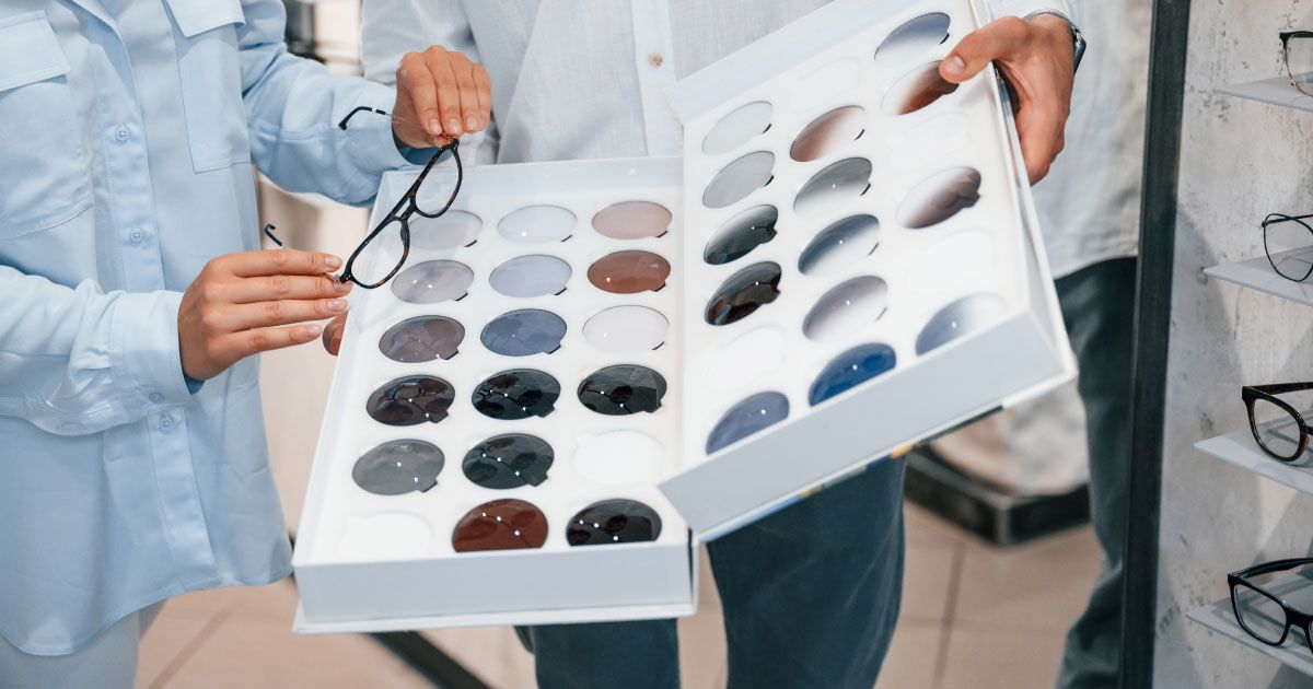 A man and a woman are holding a box of lens tints.