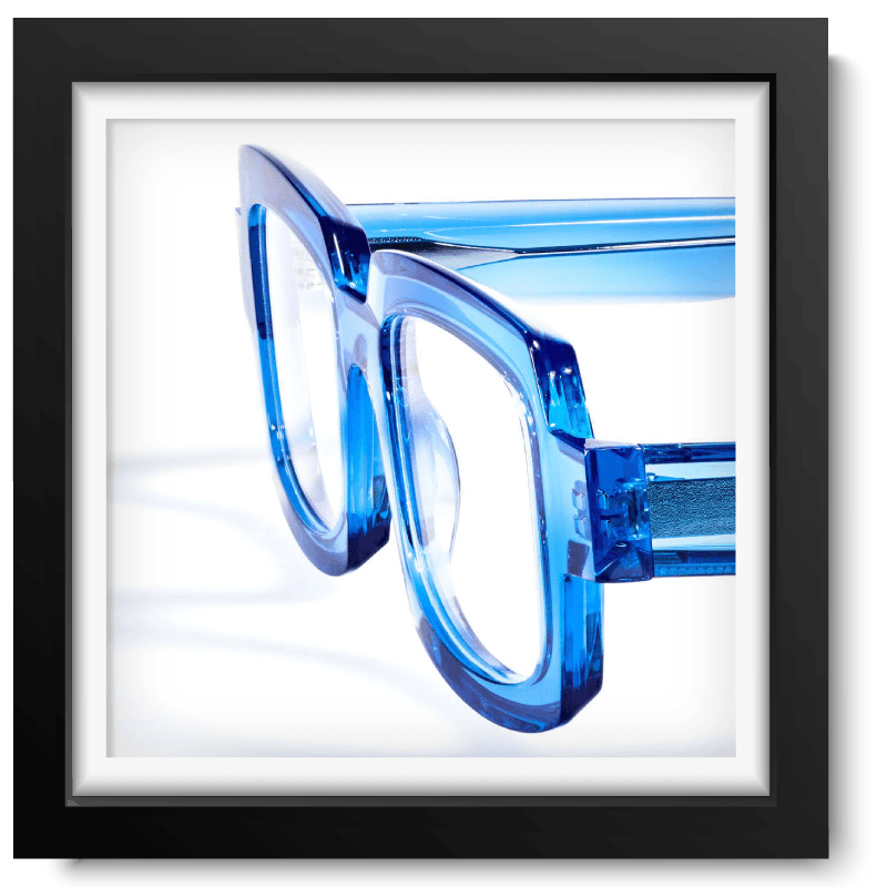 Black picture frame with a close-up picture of a blue translucent glasses