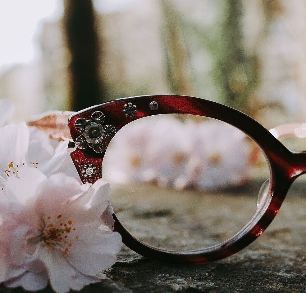 Close up of Francis Klein in a red and pink tortoise pattern with silver antique jewels