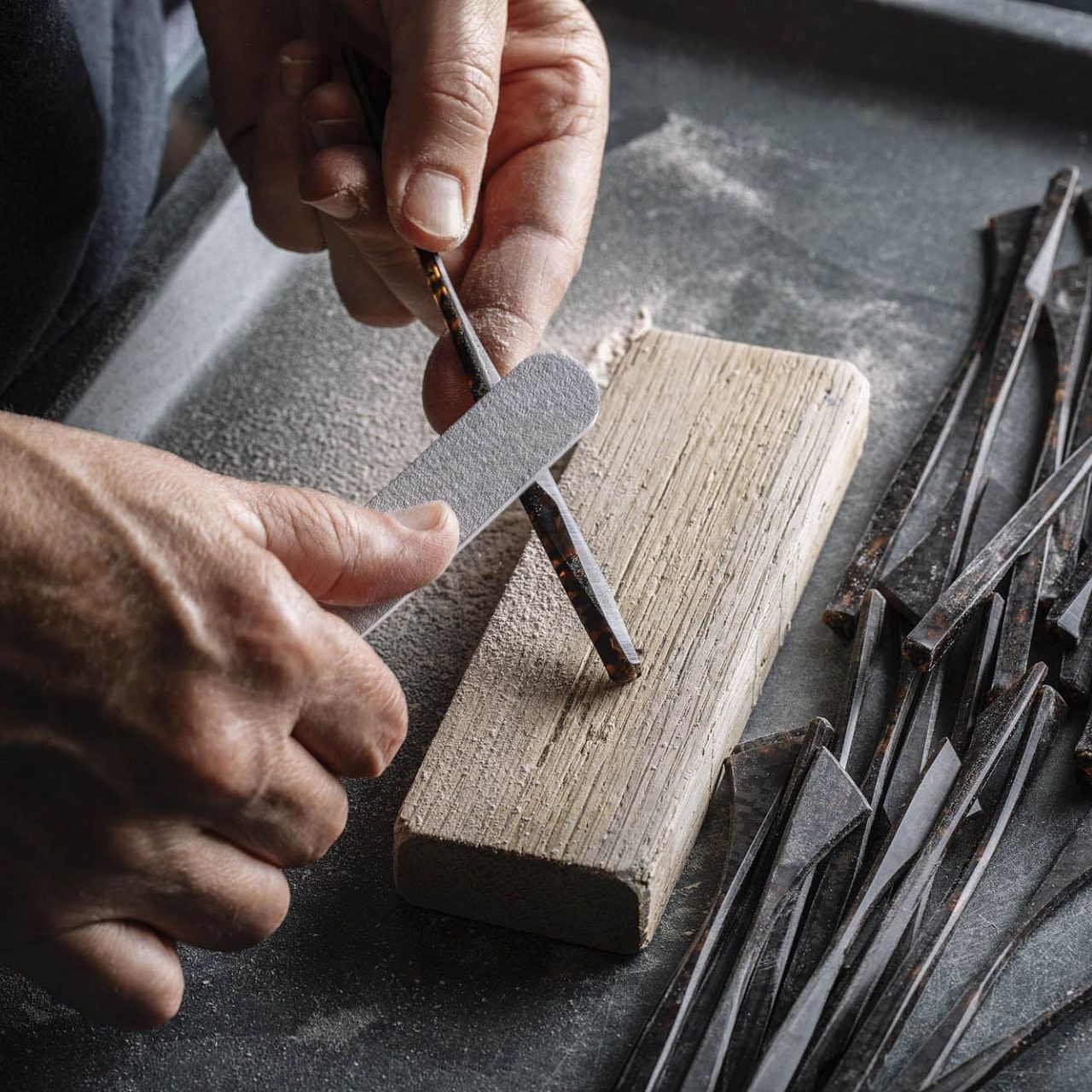 A close up of an artisan handcrafting temples for Piero Massara eyewear