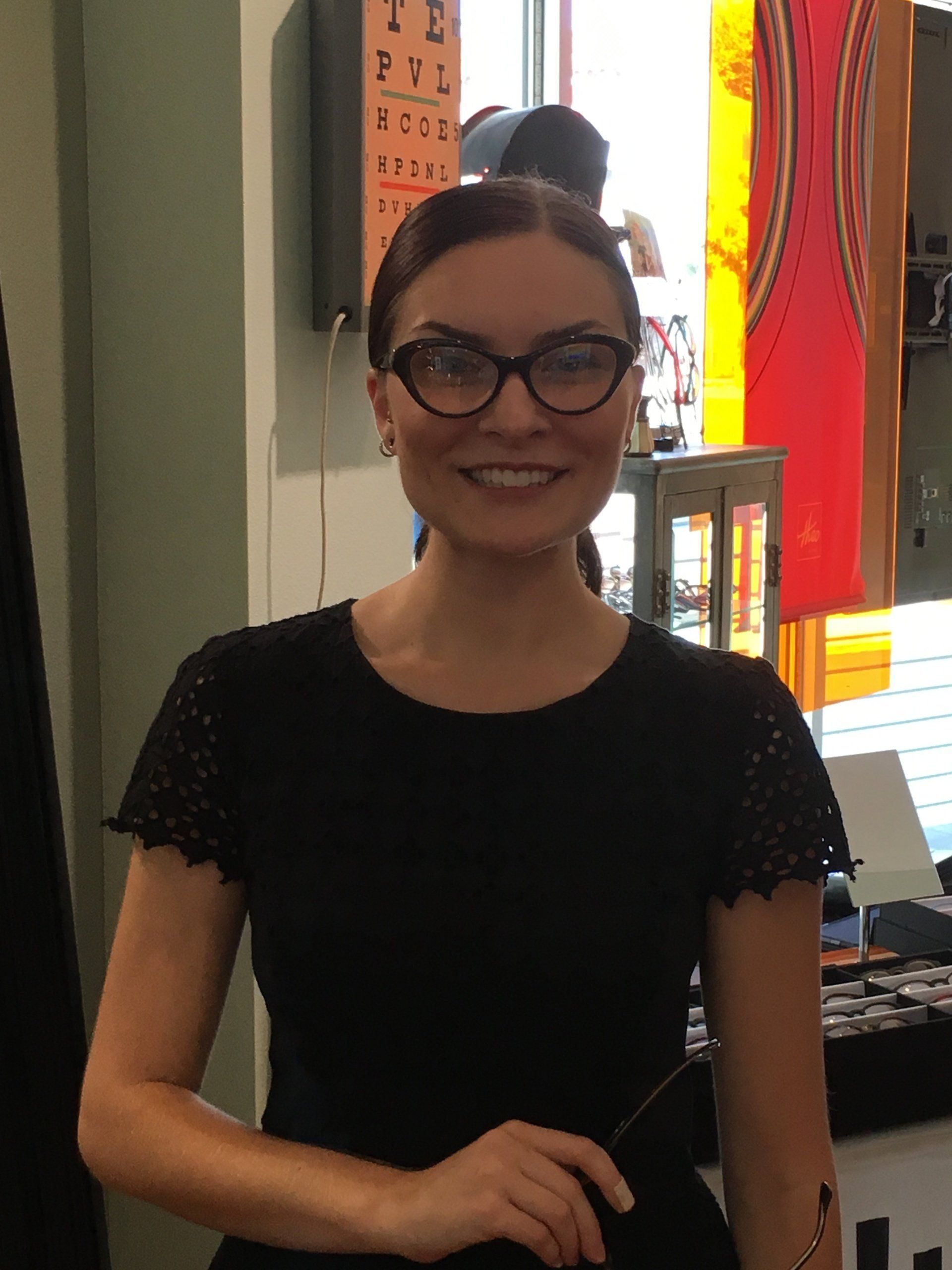Woman trying on glasses at Urban Optiks Optometry at 2016 trunk show event
