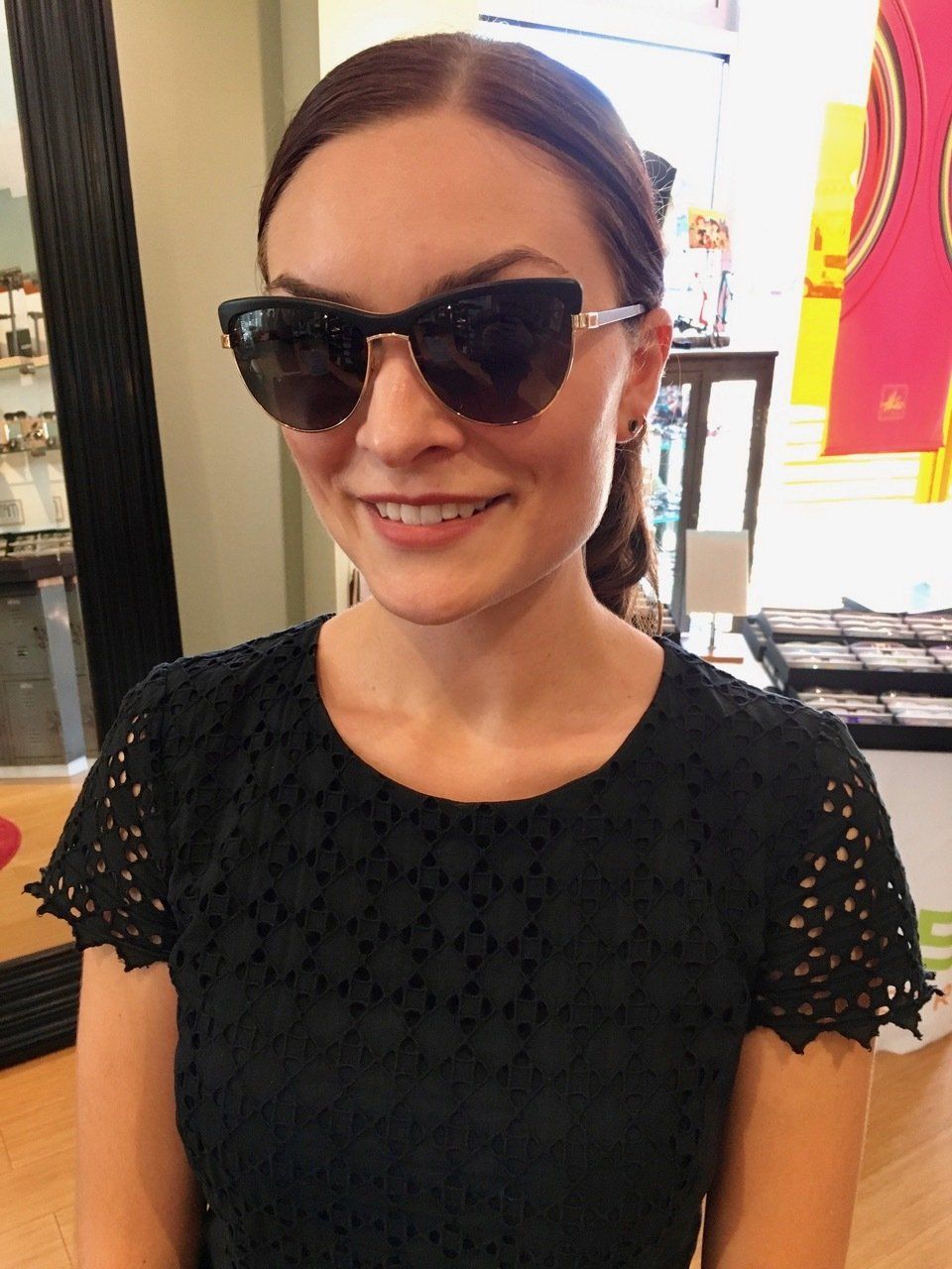 Person in black blouse modeling sunglasses at 2016 trunk show event