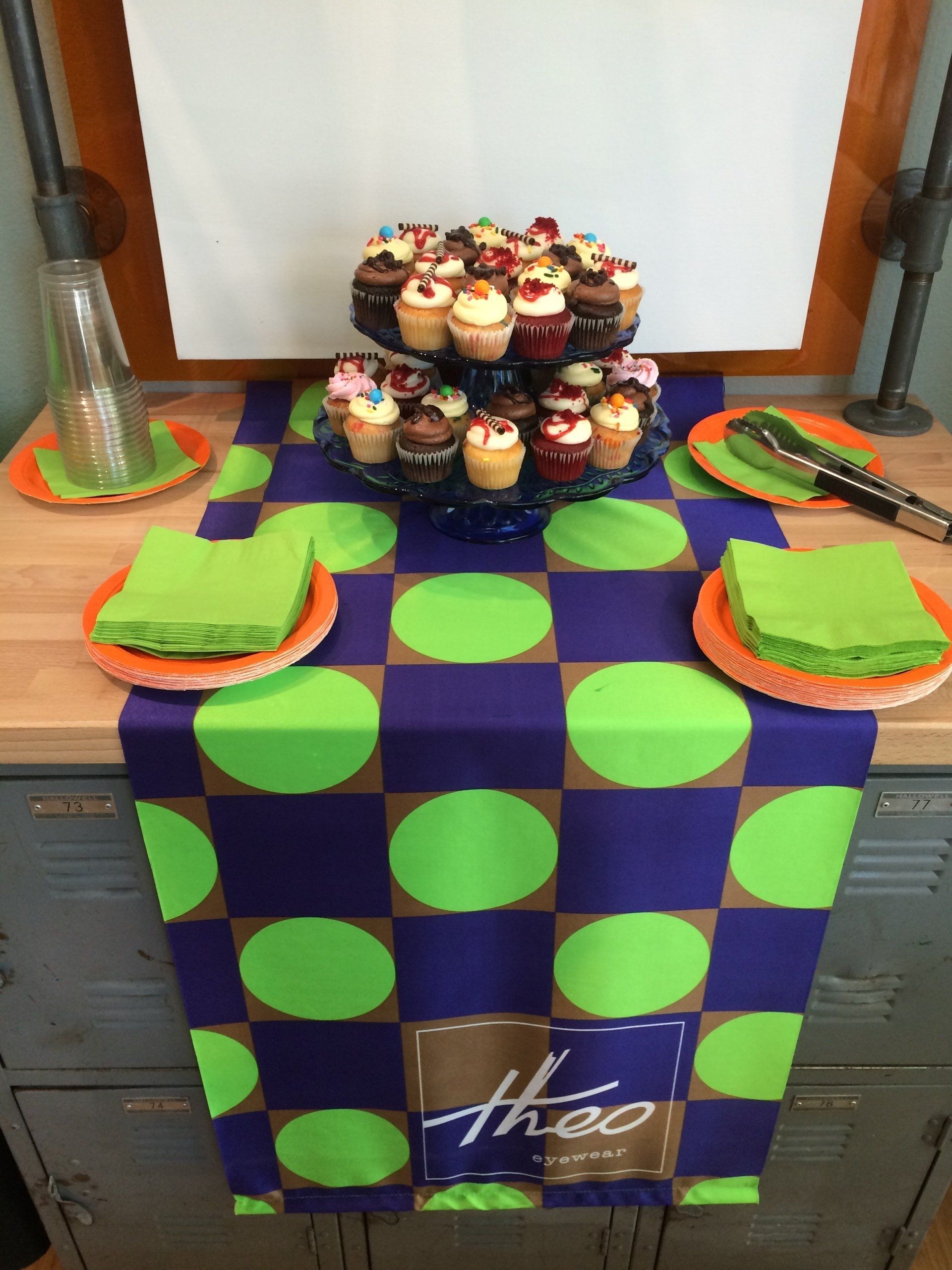 Colorful tablecloth, cupcakes, and serving ware at Theo Trunk Show event
