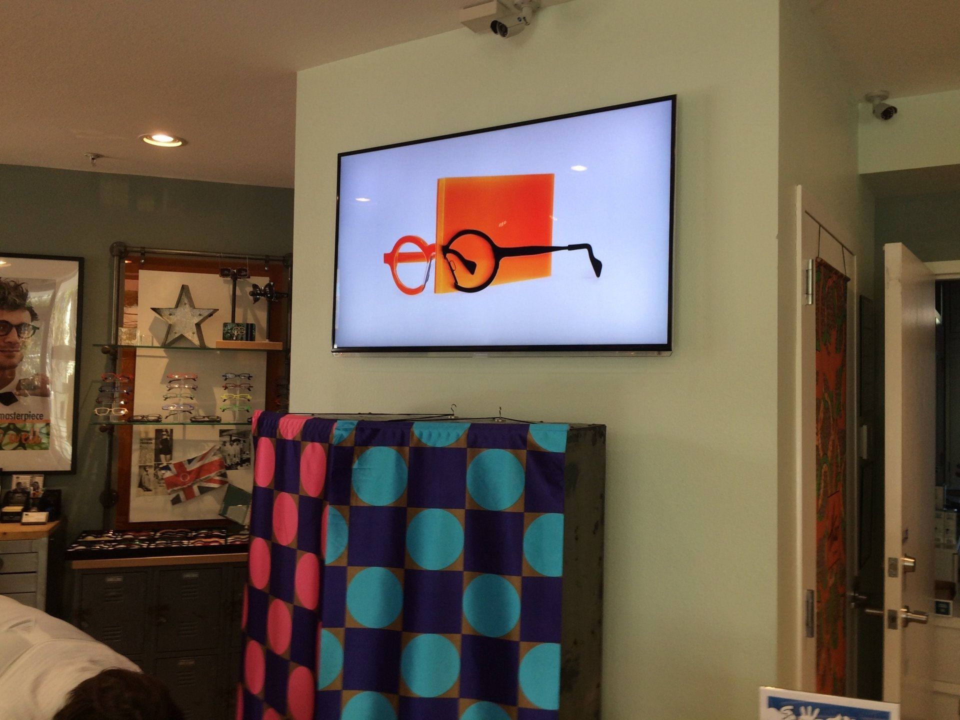 Colorful picture of eyeglasses on TV screen at Theo Trunk Show event
