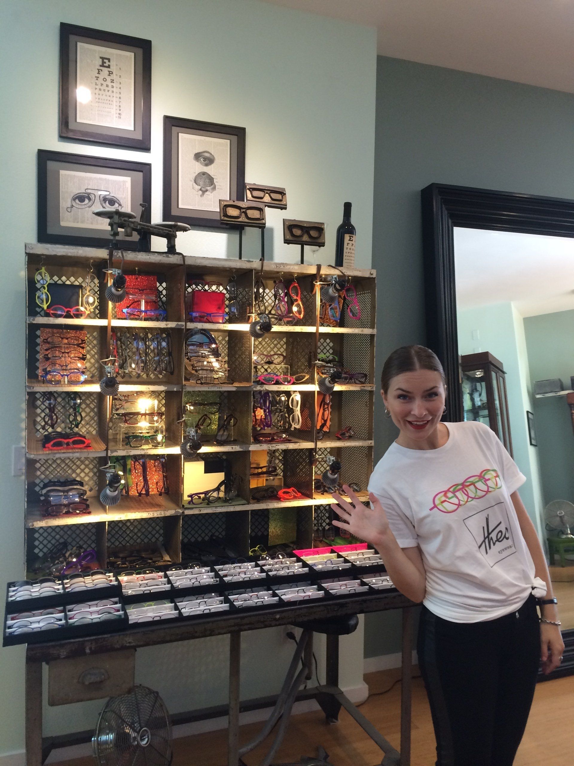 Staff member waving and smiling at Theo Trunk Show event at Urban Optiks