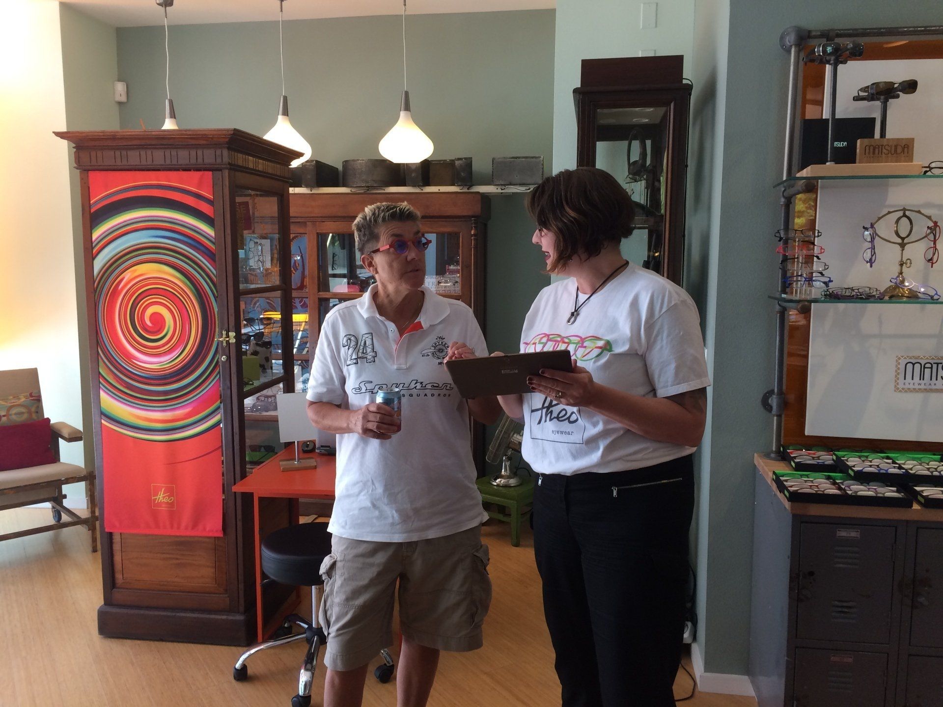 Two people discussing glasses at Theo Trunk Show event at Urban Optiks