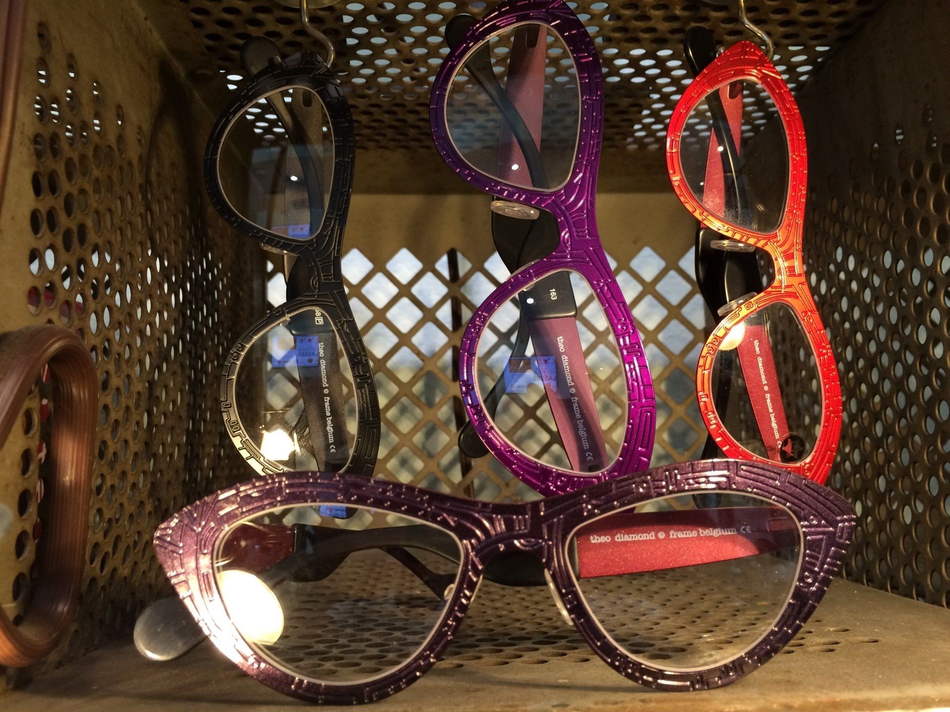 Colorful glasses hanging from wire display at Theo Trunk Show event at Urban Optiks